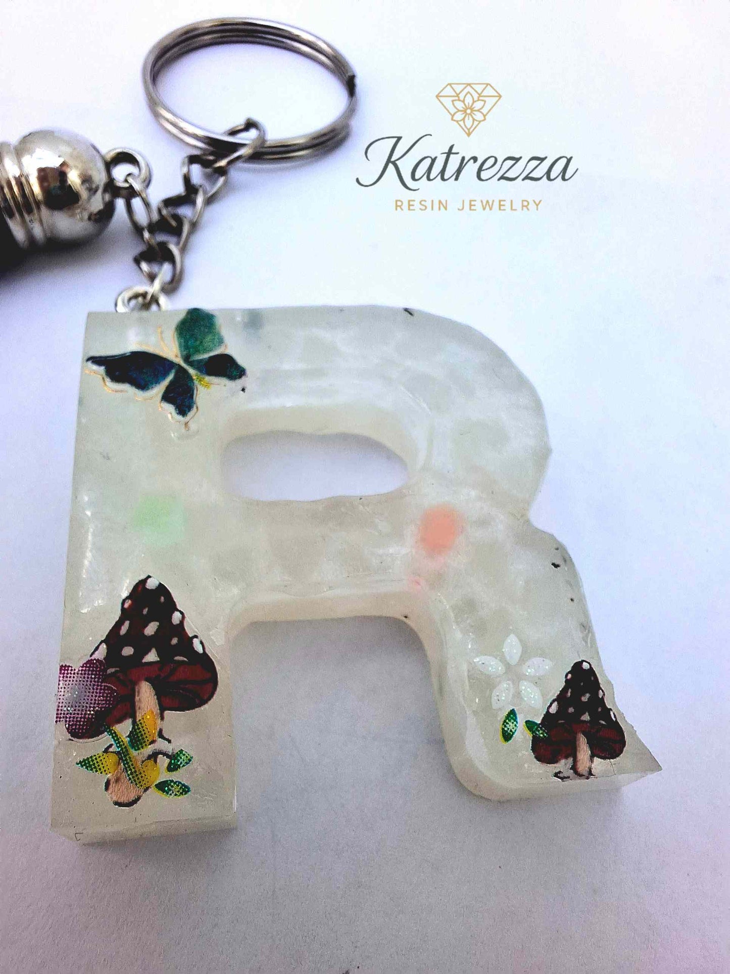 Glow-in-the-dark resin initial keychain with tassel accessory