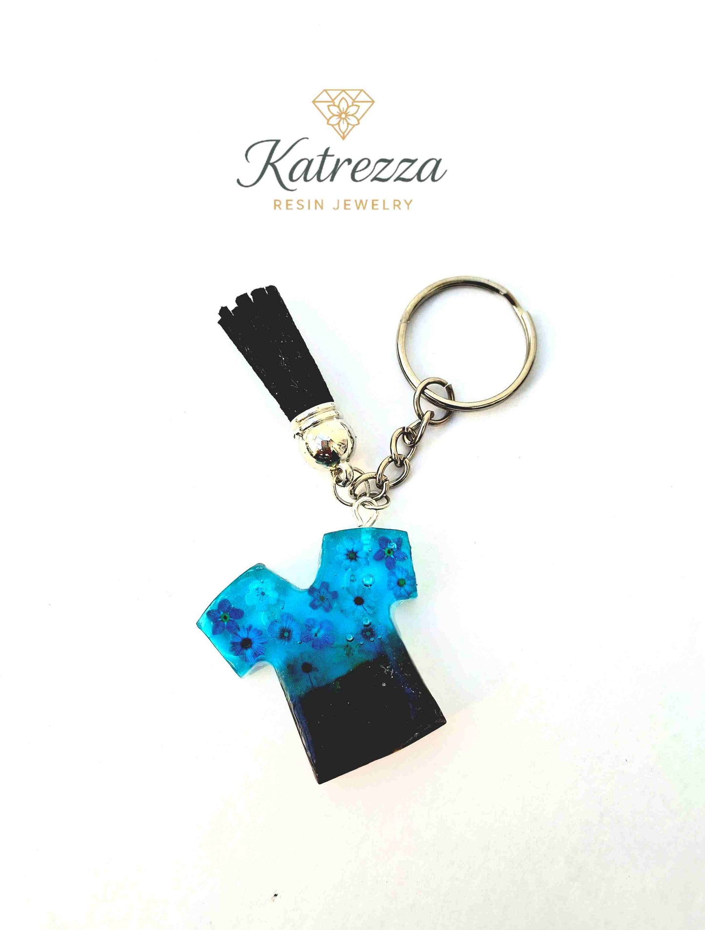 Close-up of resin T-shirt keychain showing gold flakes and flower stickers.