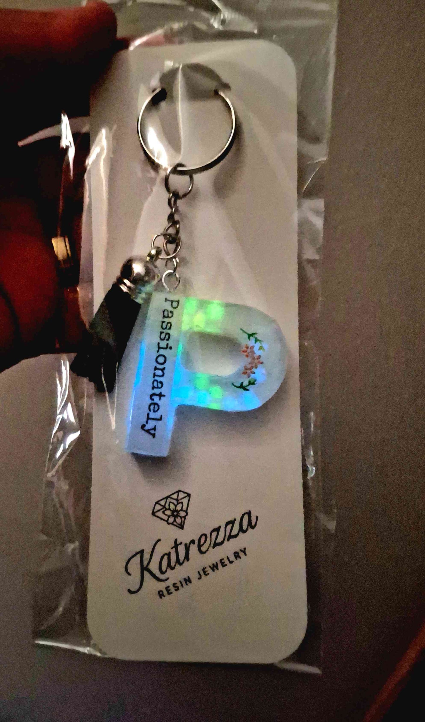 Glow-in-the-dark resin letter P keychain with flower design.