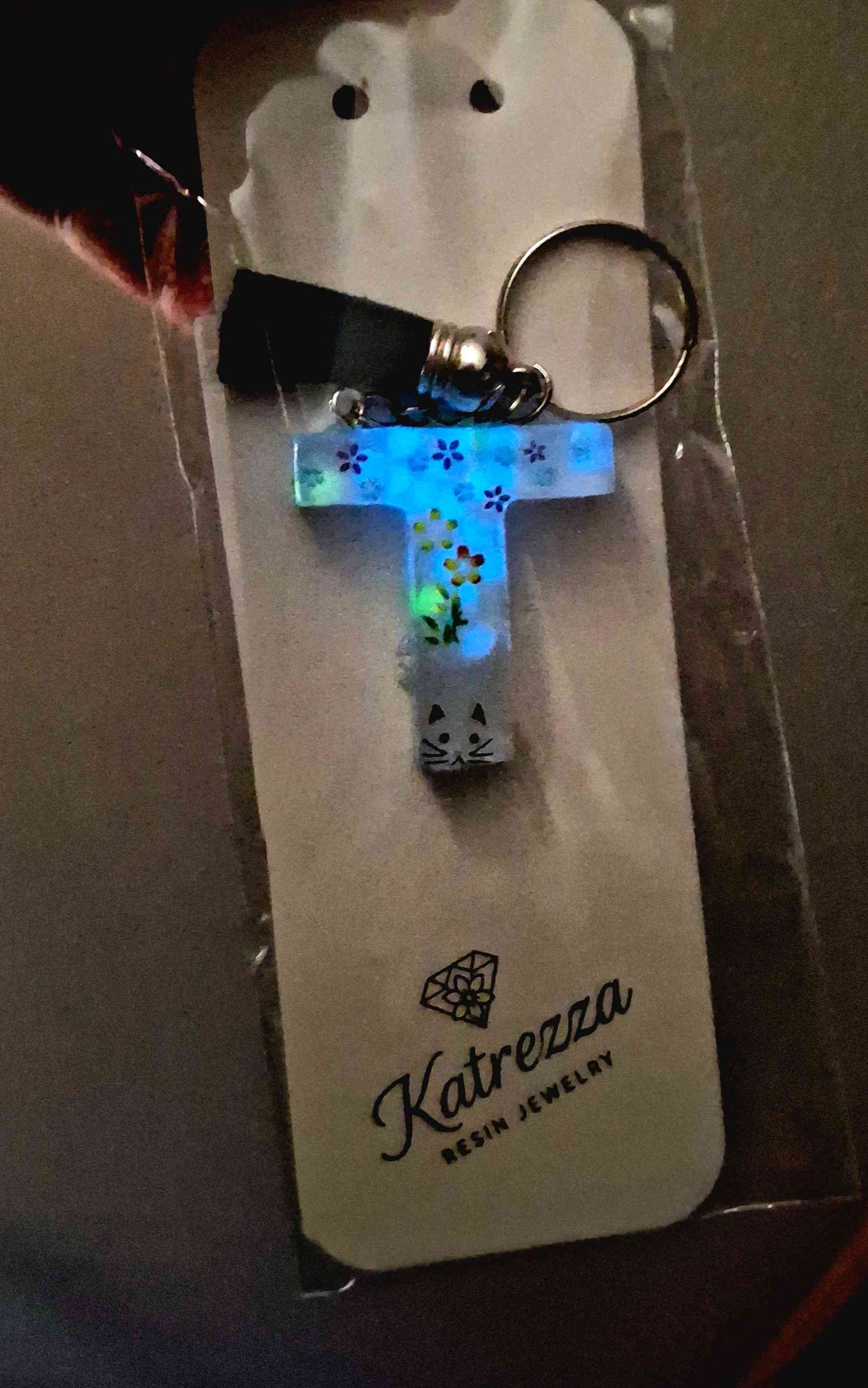 Handmade resin letter T keychain with black tassel, floral stickers, and cat design.
