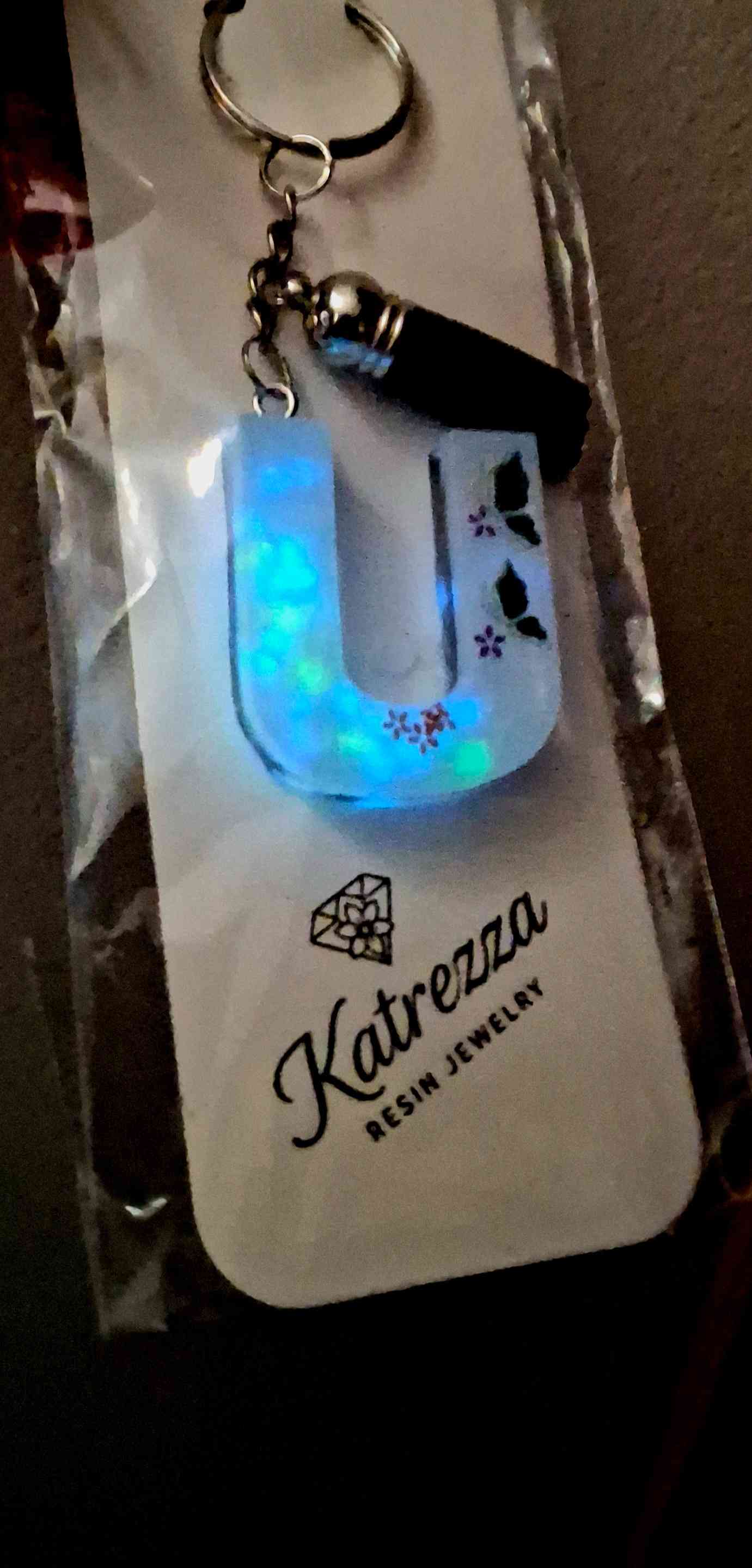 Glow-in-the-dark resin letter U keychain illuminated in the dark