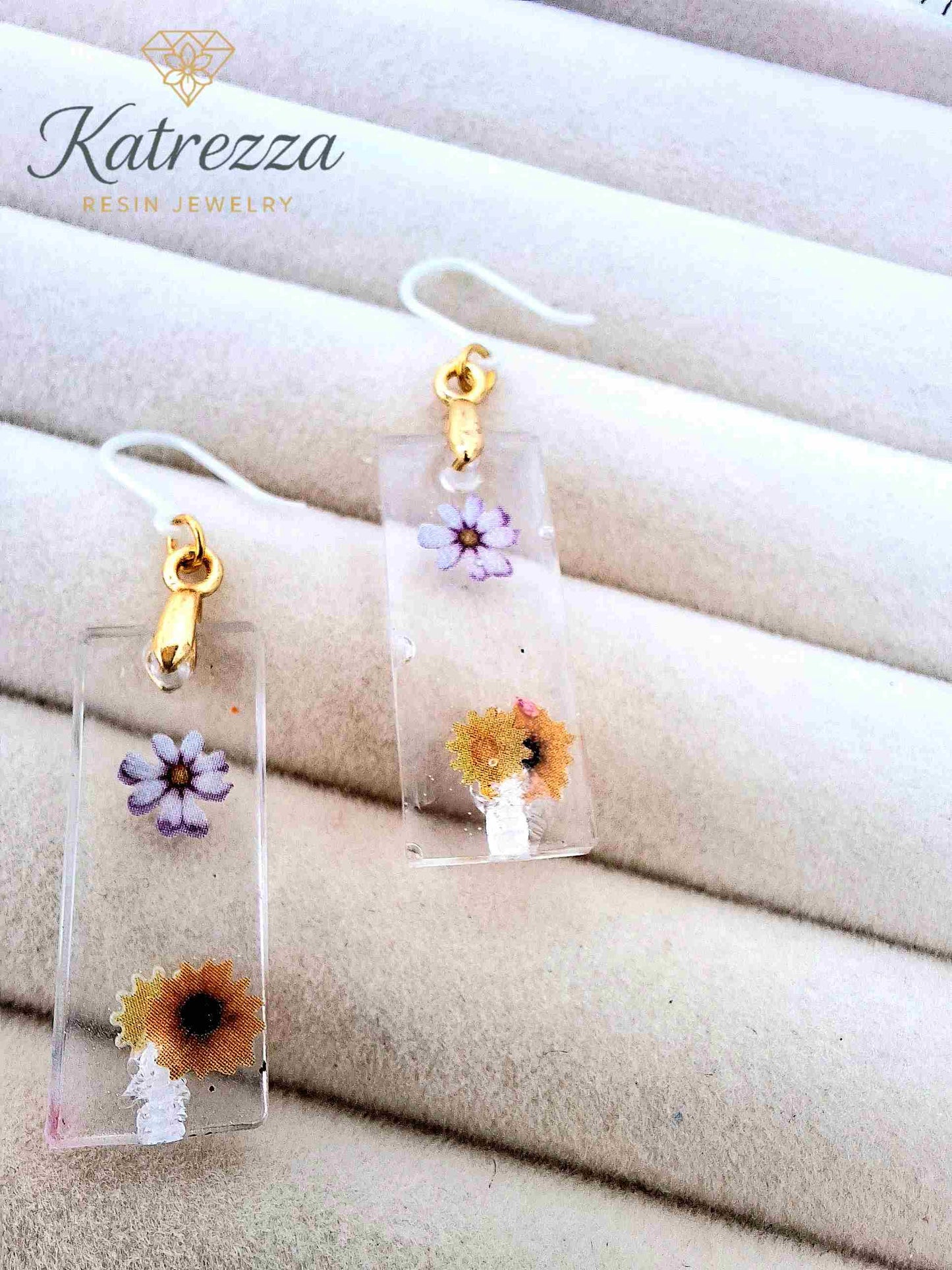Close-up of girls’ sunflower and purple flower resin earrings