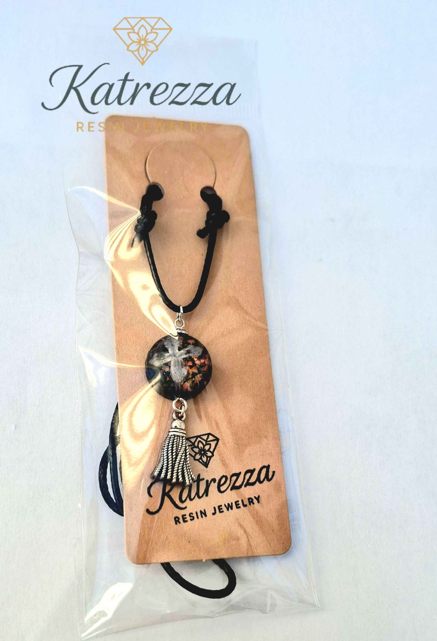 “Handmade resin necklace with real lilac flower, glitter, and silver tassel on adjustable black cord – Katrezza packaging.”