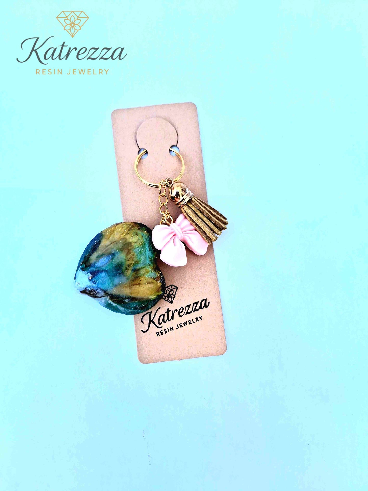 "Back view of handmade resin heart keychain showing green and amber swirls – Imperfection Collection"