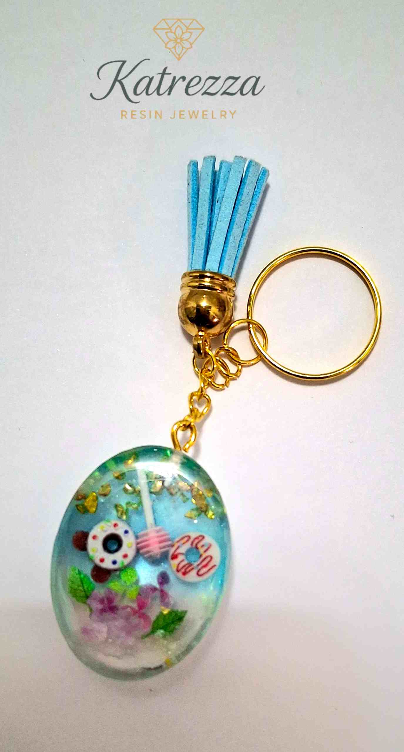 Back view of oval resin keychain showing embedded sweets and floral details, handmade by Katrezza.
