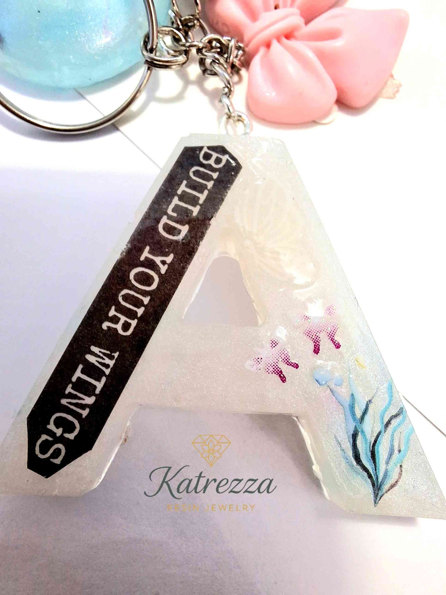 Handmade resin A keychain with tassel, pink bow, and blue globe ch