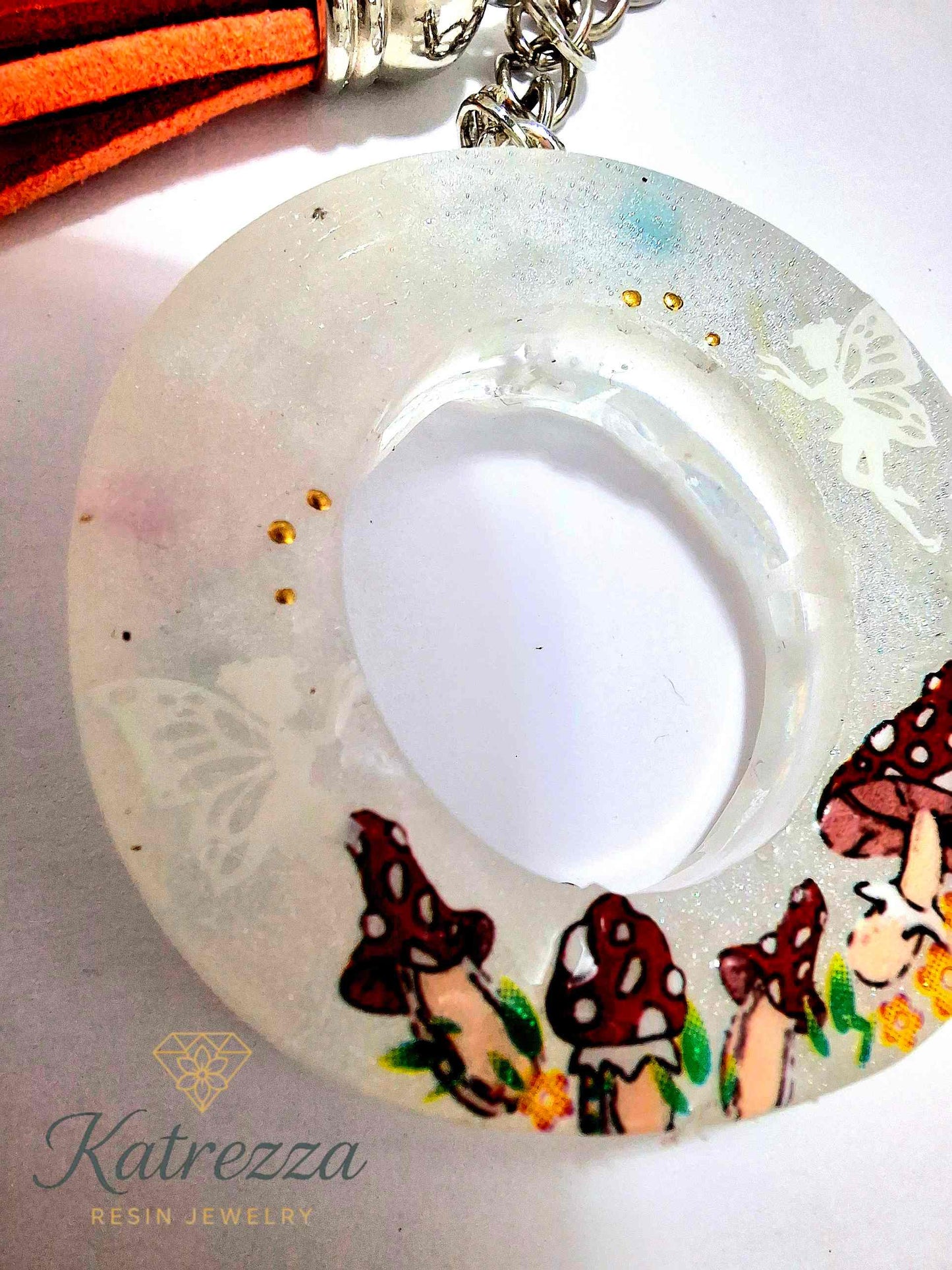 Fantasy-style resin O keychain with fairies, mushrooms, and shimmer.