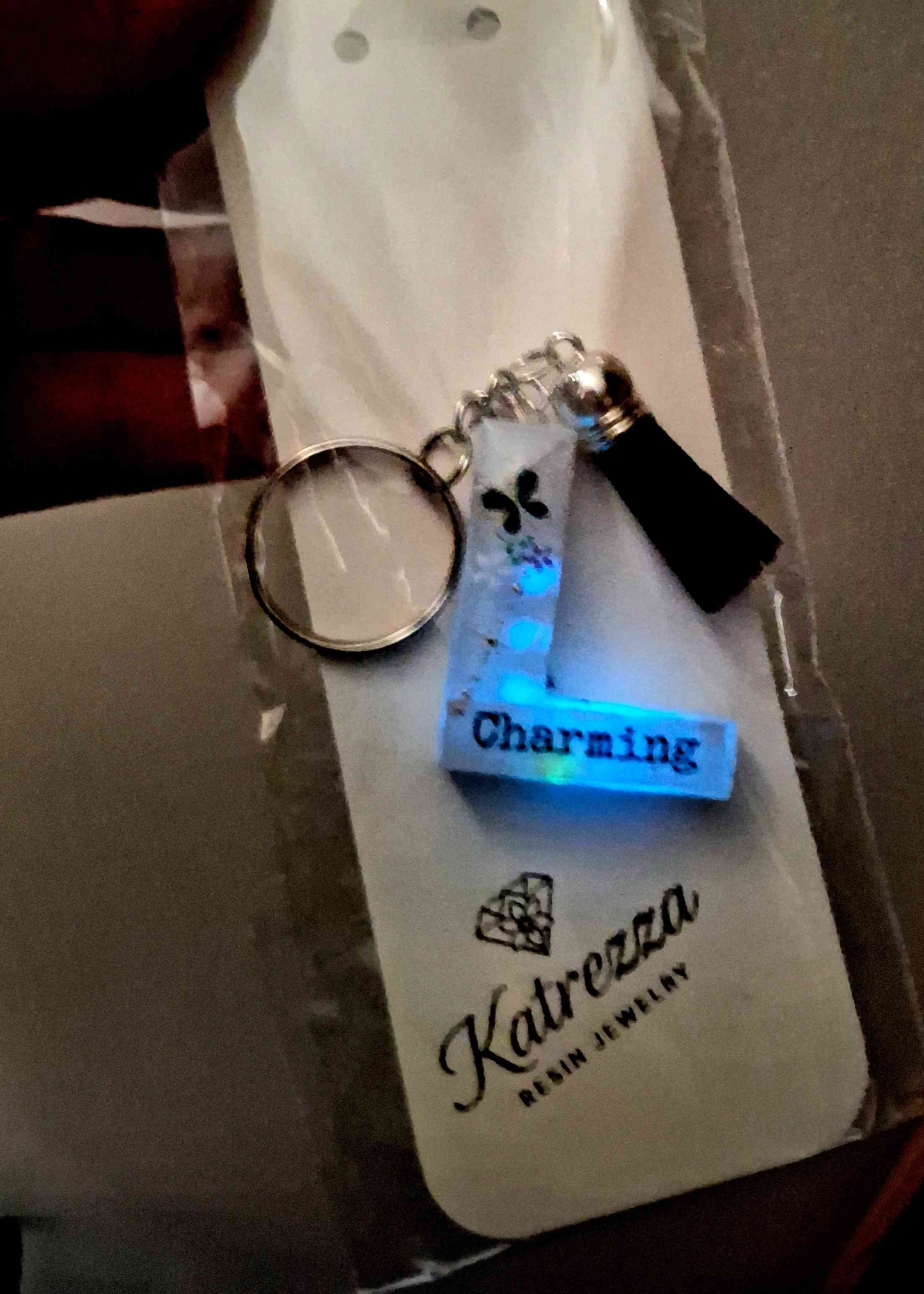Glow-in-the-dark resin letter L keychain with “Charming” text.