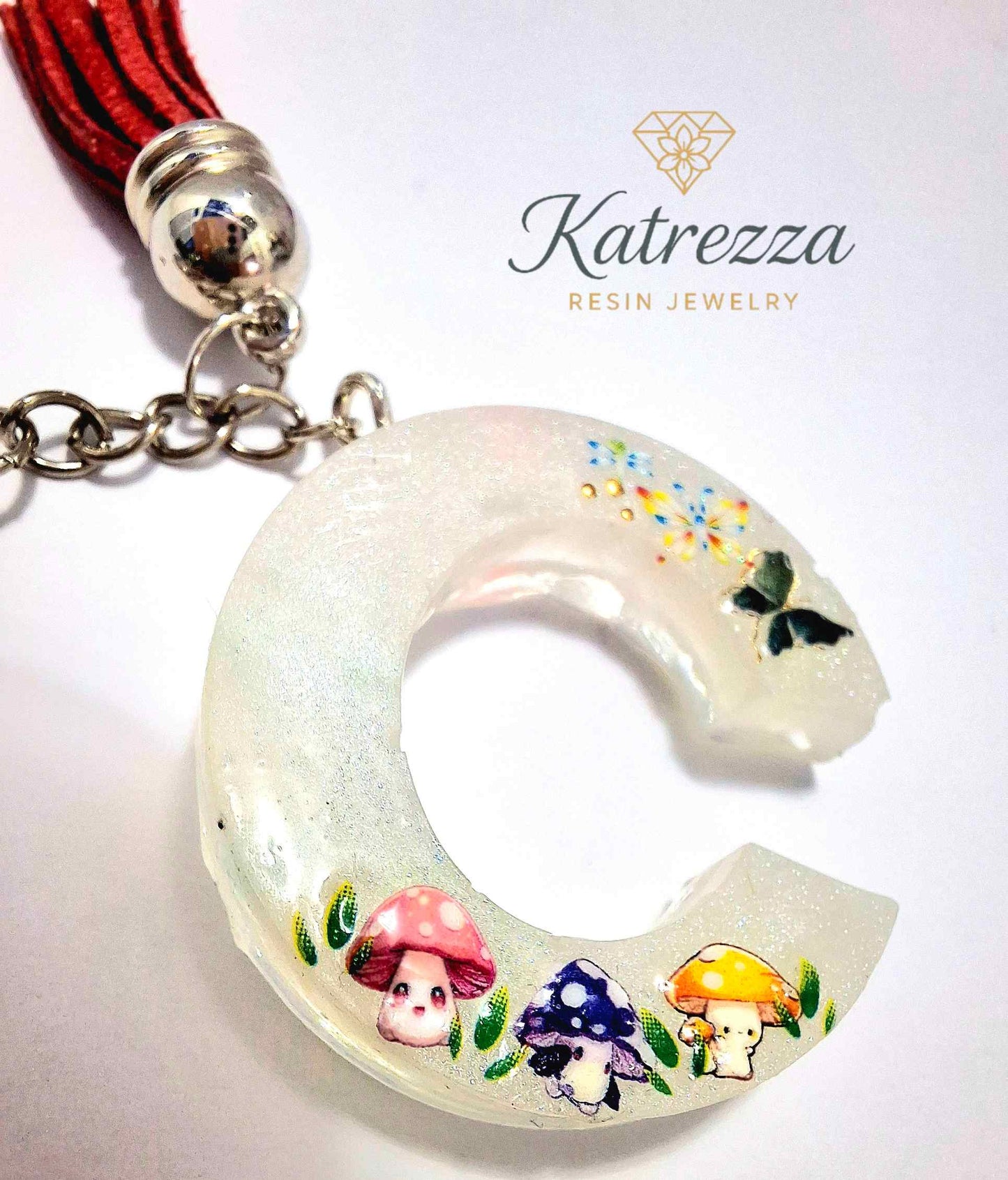 Handmade resin C keychain glowing in the dark with cute decorations.