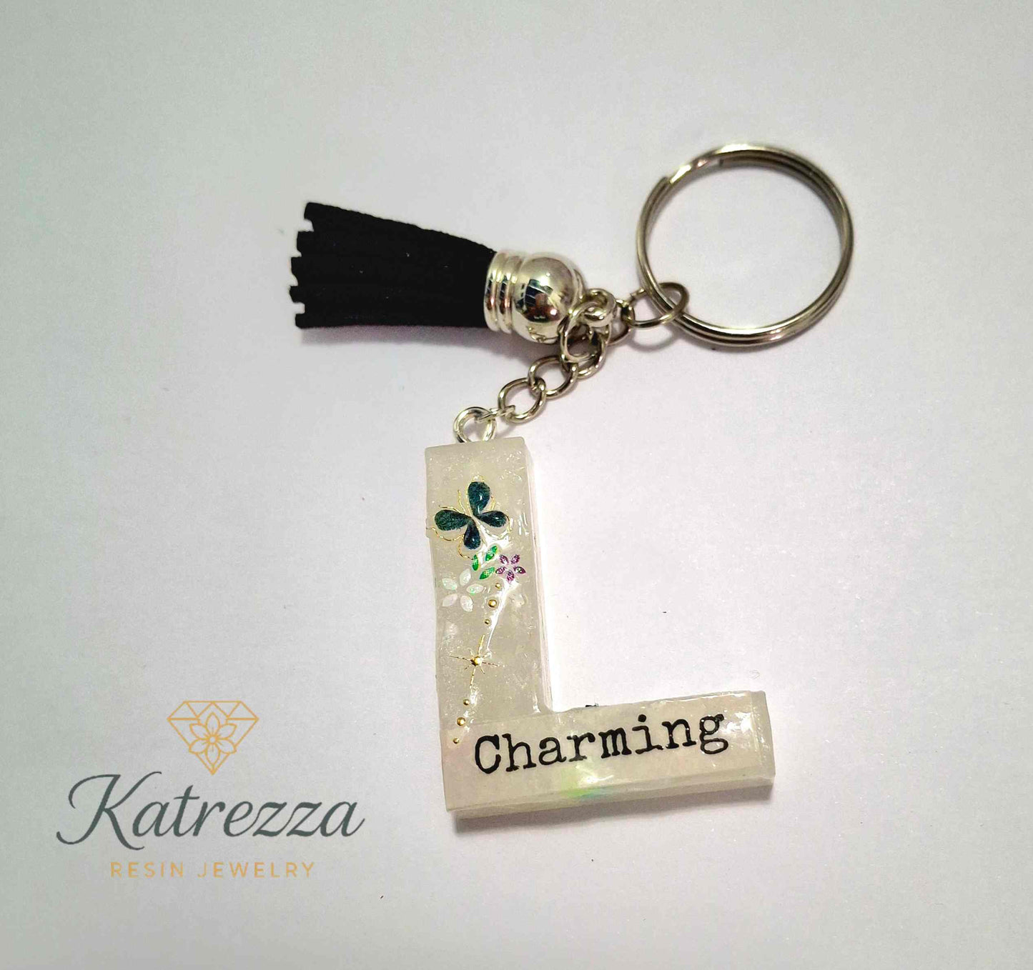 Close-up of Charming resin L keychain with shimmer design.
