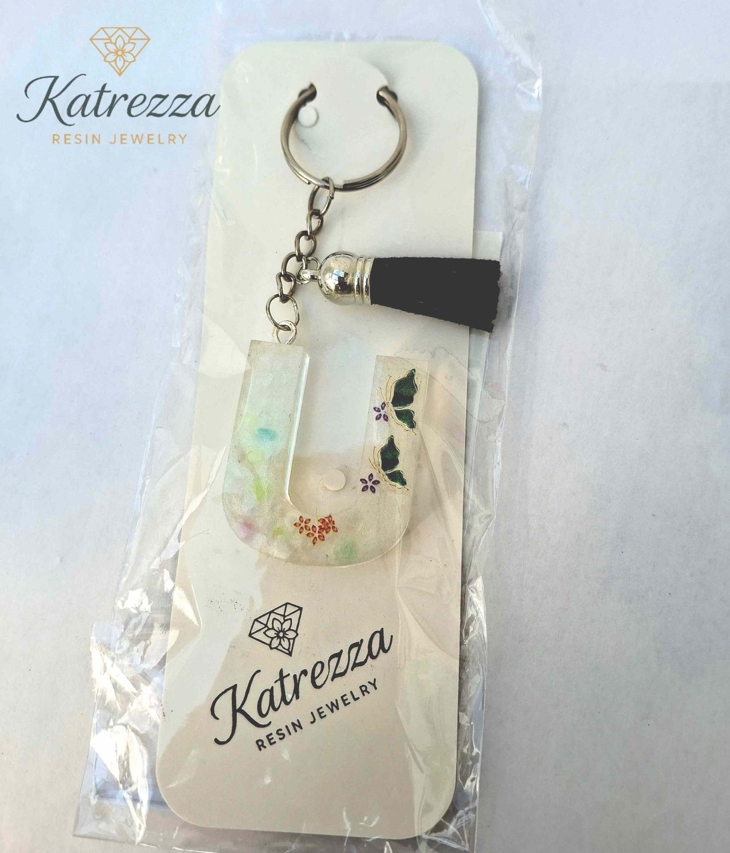 Packaged handmade resin letter U keychain by Katrezza