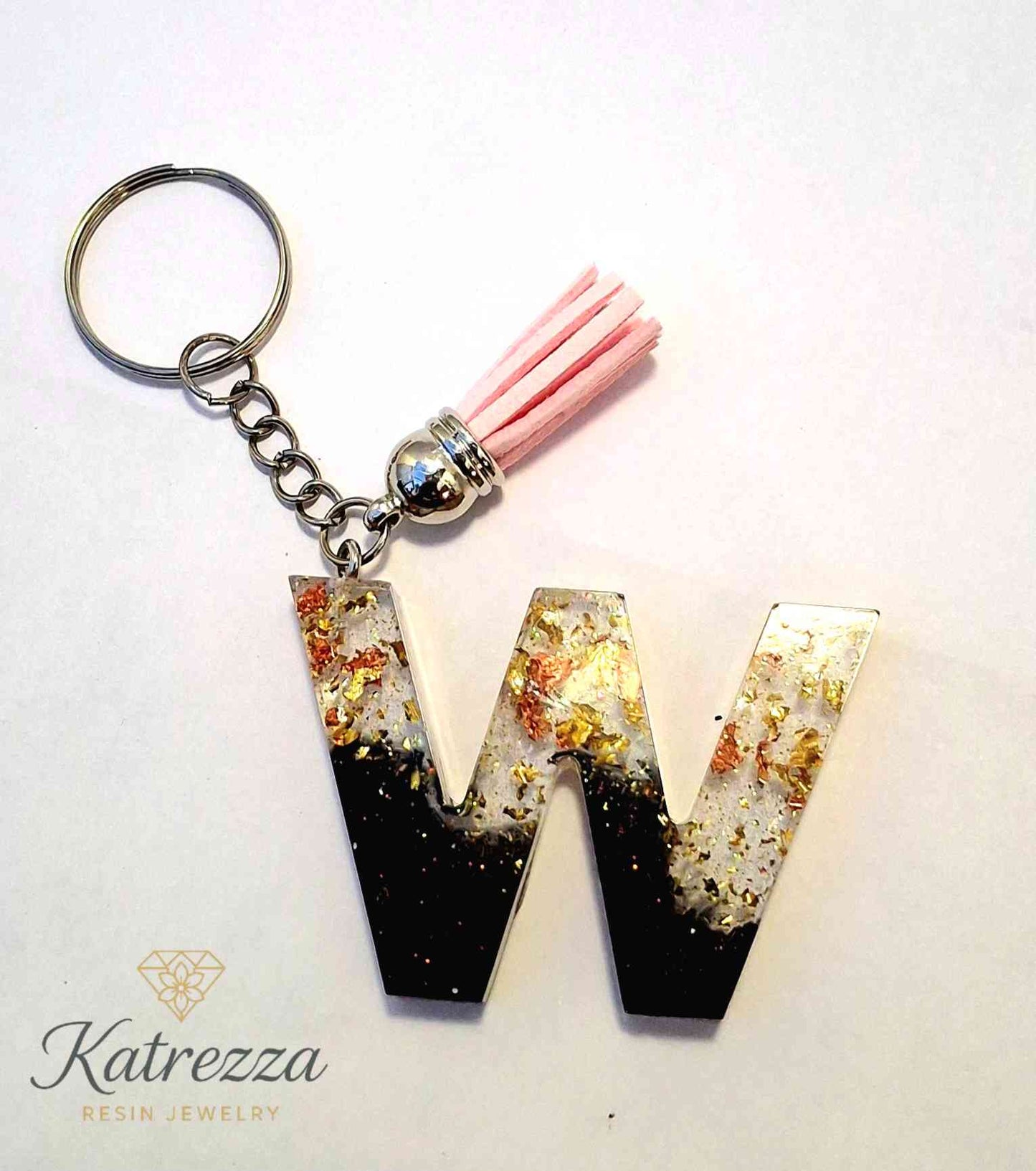 Handmade resin W keychain with black ombre and pink tassel.