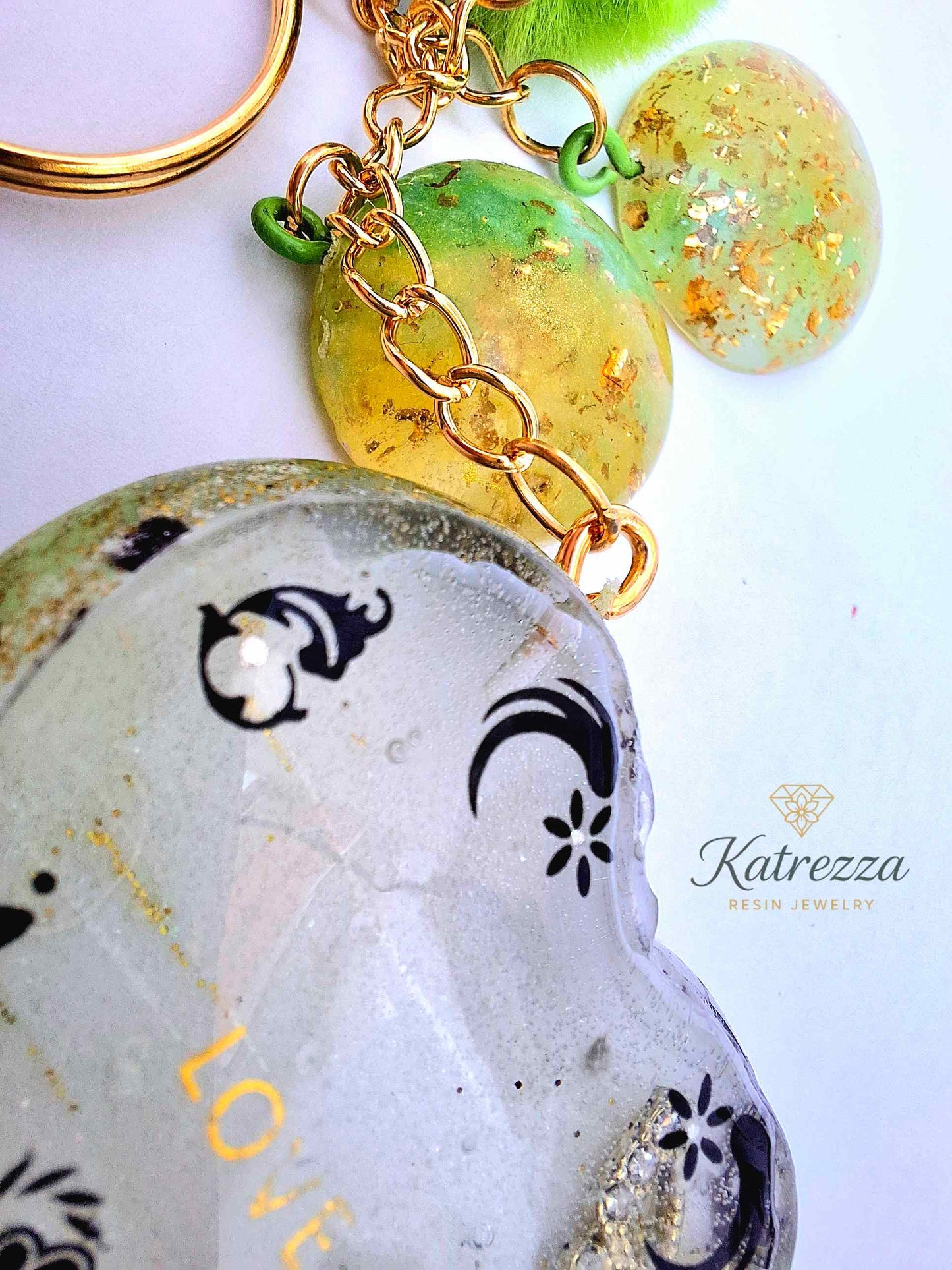 "Close-up of resin discs with gold flakes, part of green resin heart keychain – Katrezza Accessories"