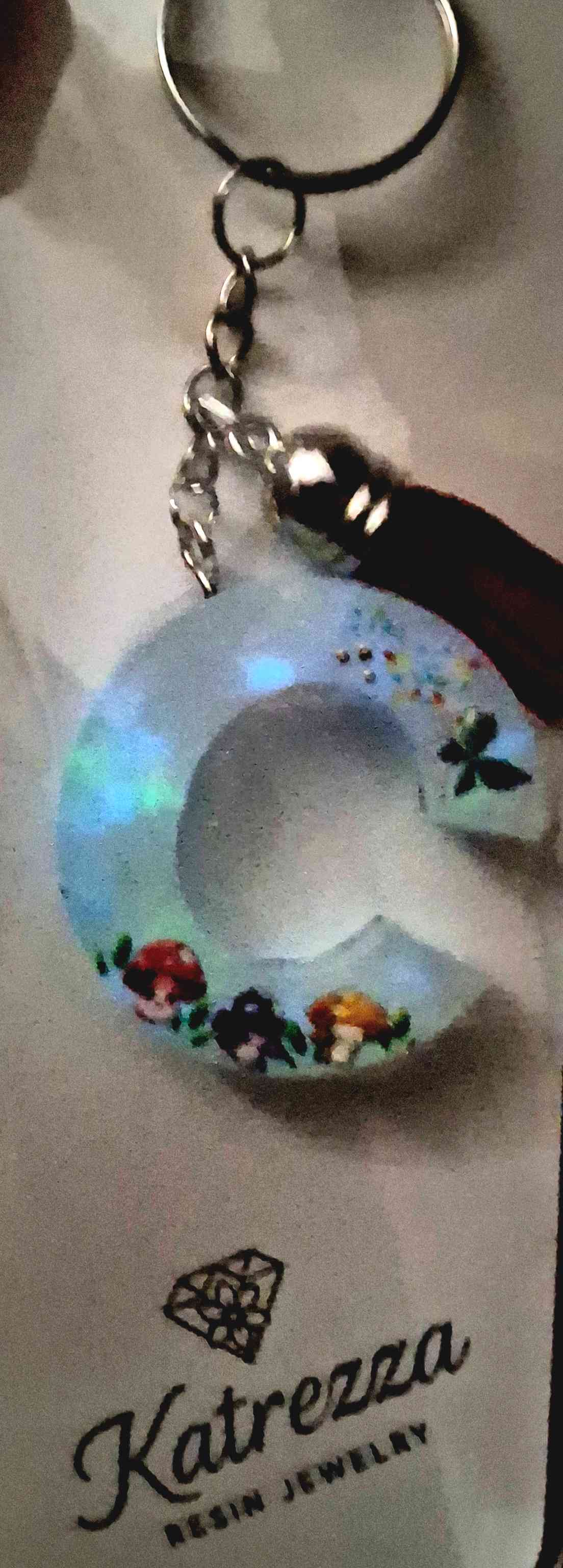 Resin C keychain on chain with red tassel, glow-in-the-dark shimmer, and sticker accents.