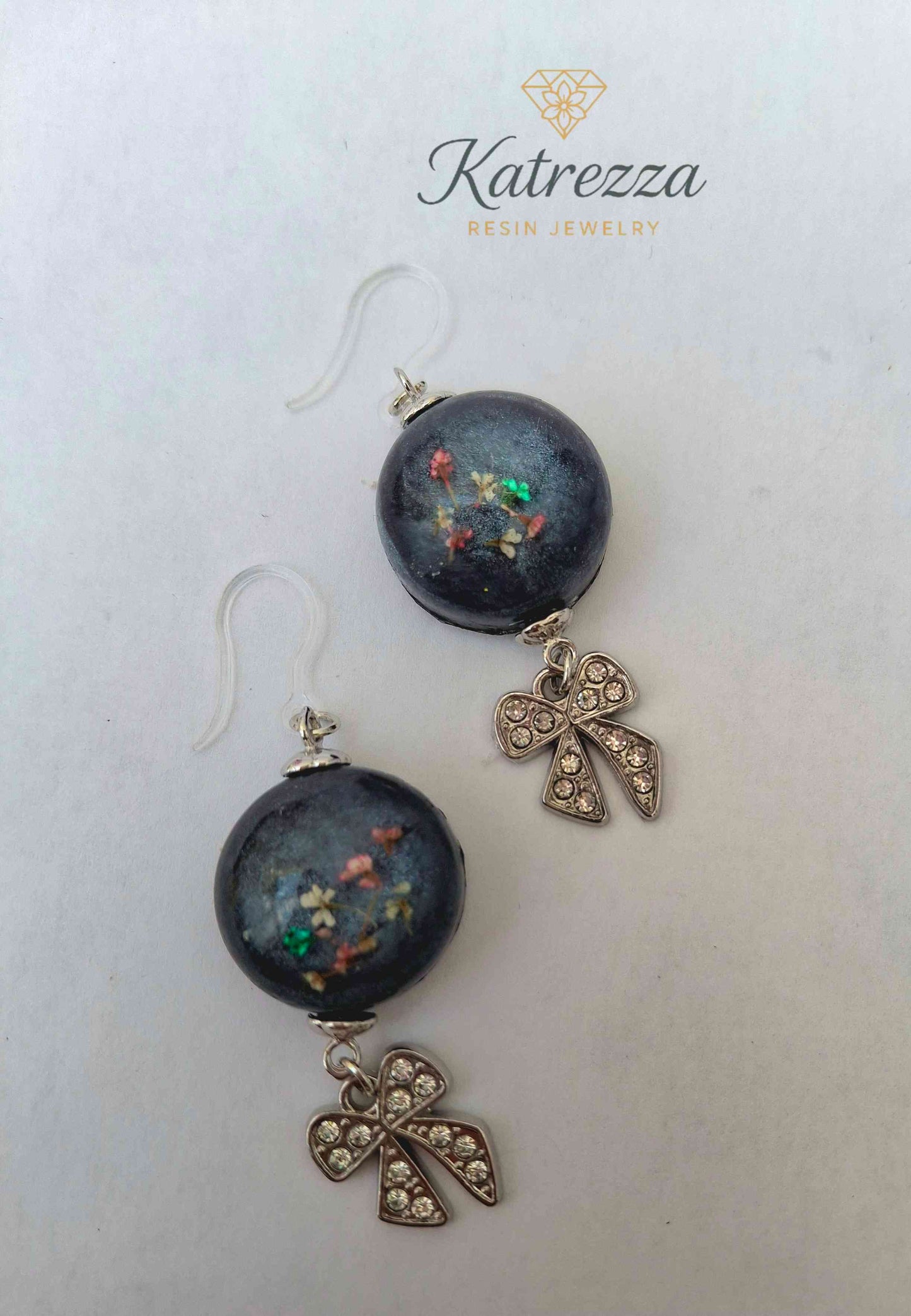 Handmade resin earrings with real flowers and silver bow charm on hypoallergenic hooks
