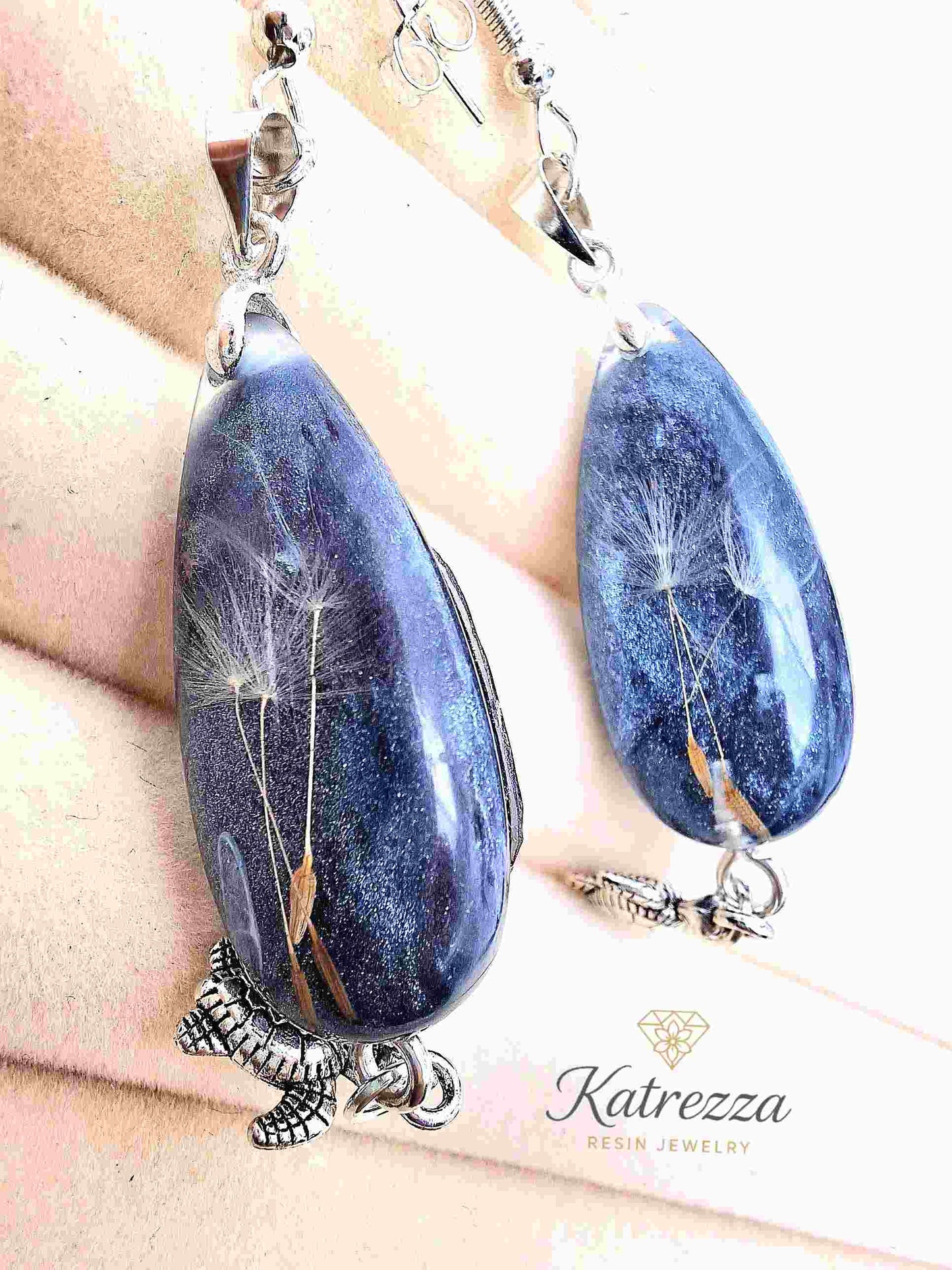 Pair of dandelion resin earrings with sterling silver hooks and turtle charms.