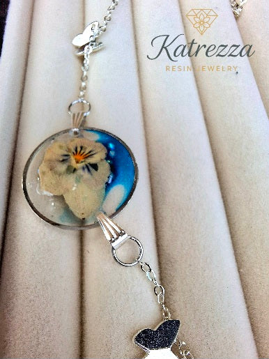 Pressed Flower Resin Necklace with Butterfly Charms – 45 cm Silver Chain
By Katrezza
