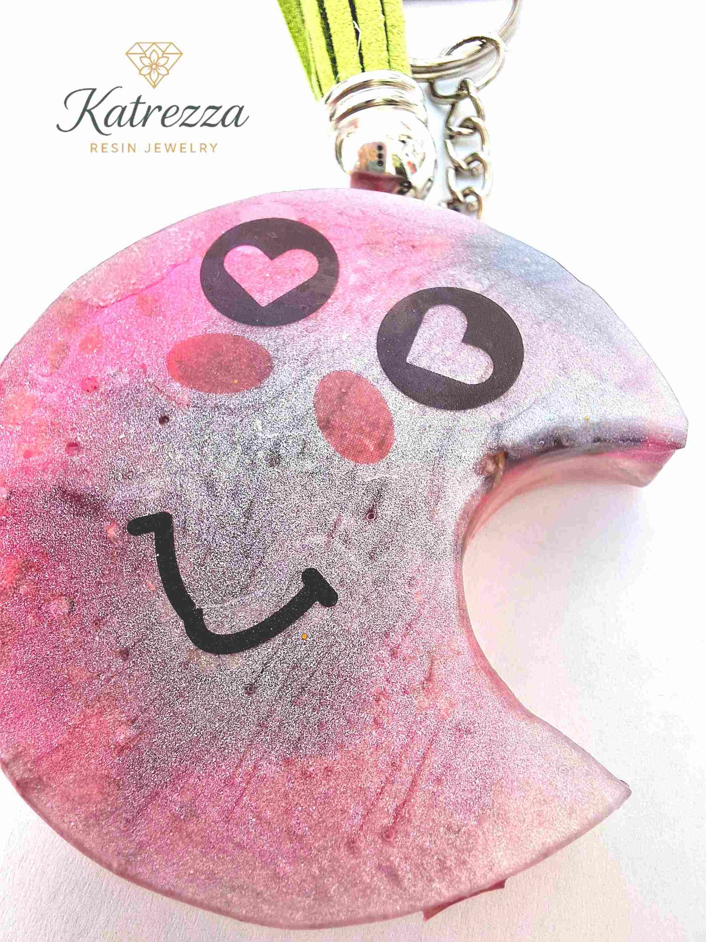 Smiley face design on pink glitter resin moon keychain.