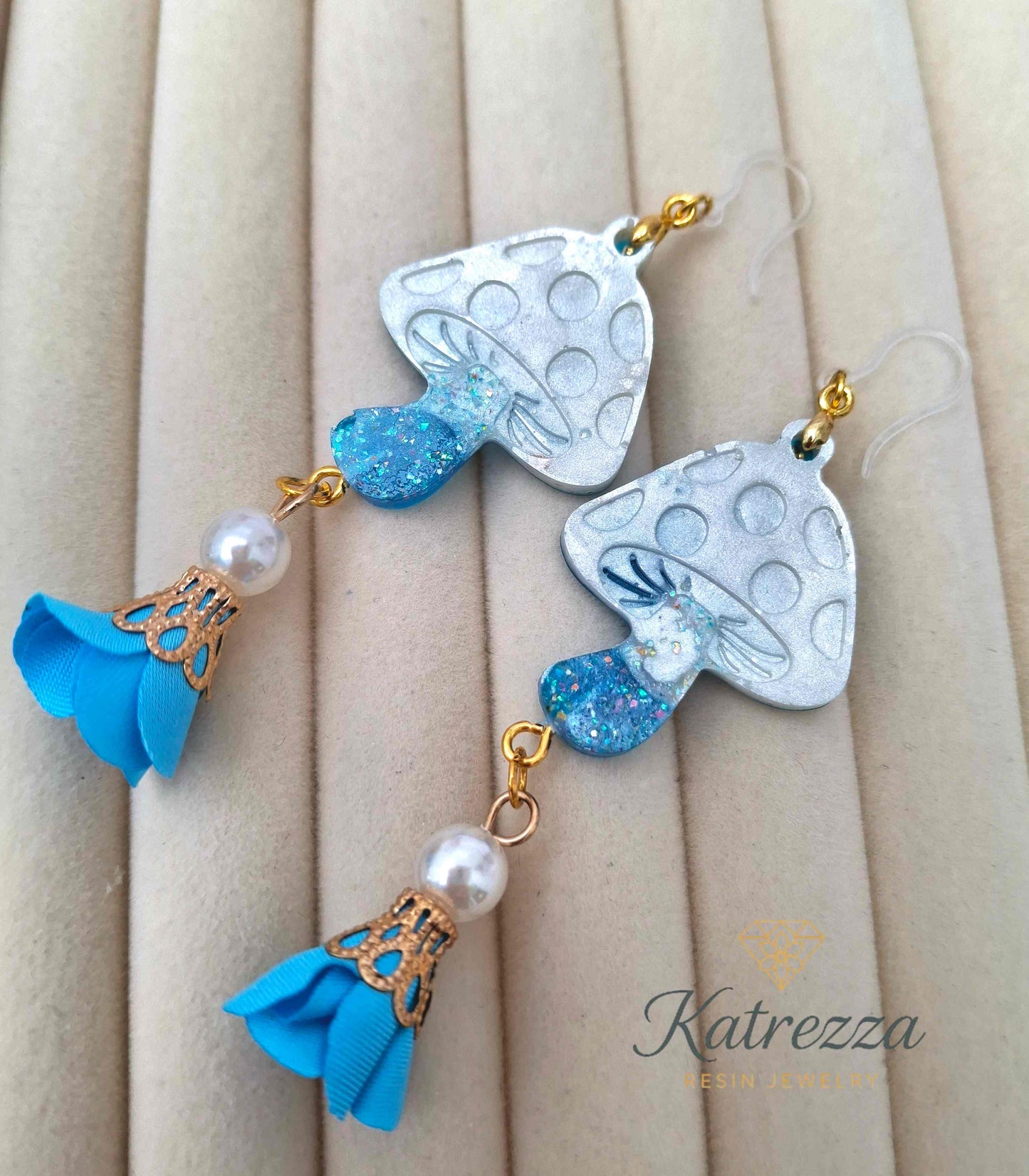 "Handmade double-sided resin mushroom earrings featuring glittery white caps, blue glitter stems, pearls, and flower charms – Katrezza Jewelry"