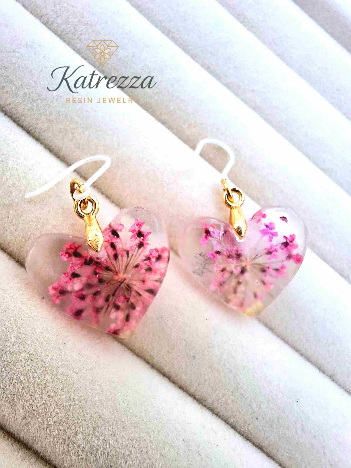 Close-up of tiny pink flower heart resin earrings for kids