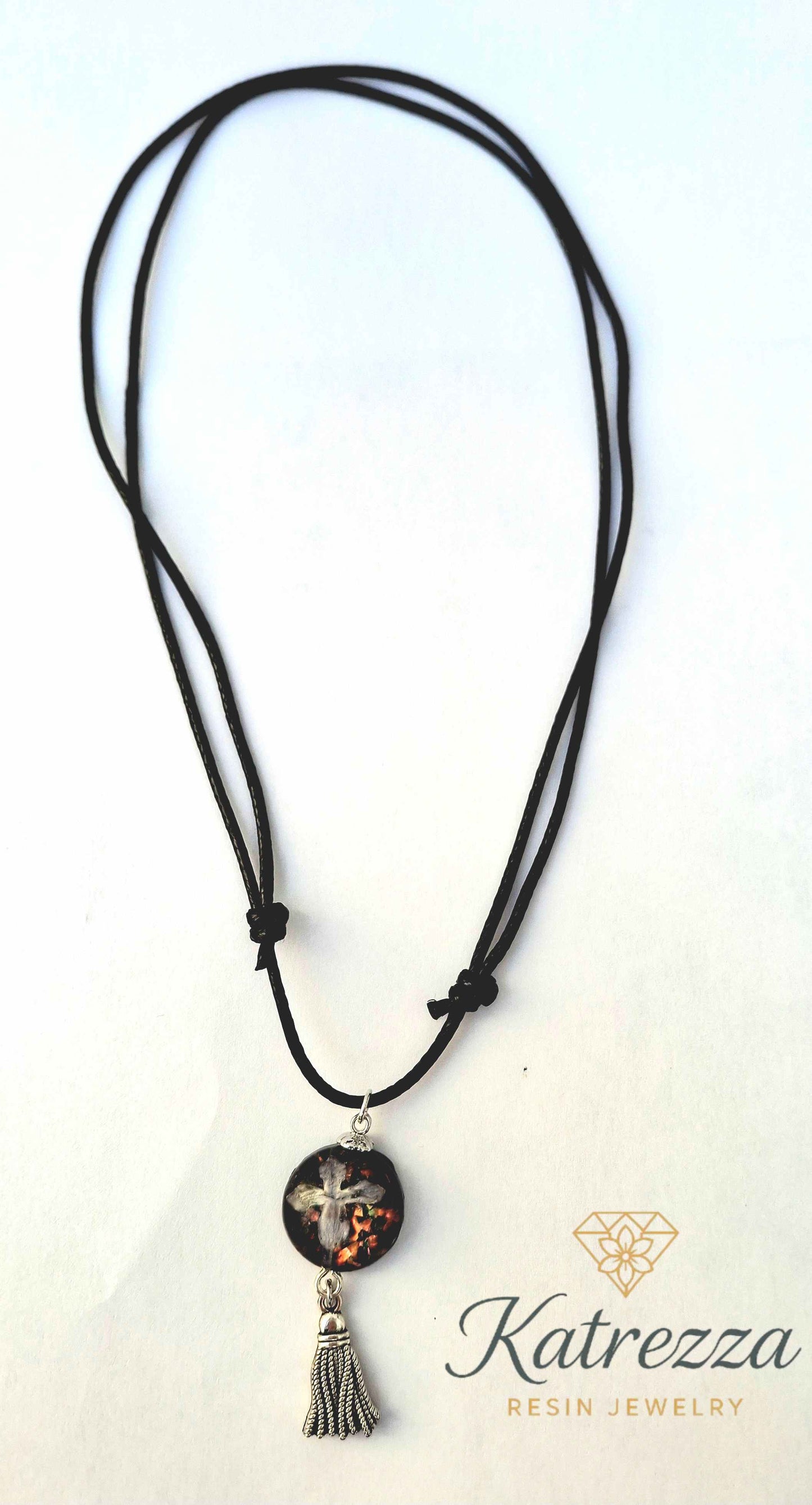 Adjustable black cord necklace featuring real lilac flower in resin pendant with glitter and silver tassel charm – Katrezza artisan jewelry.