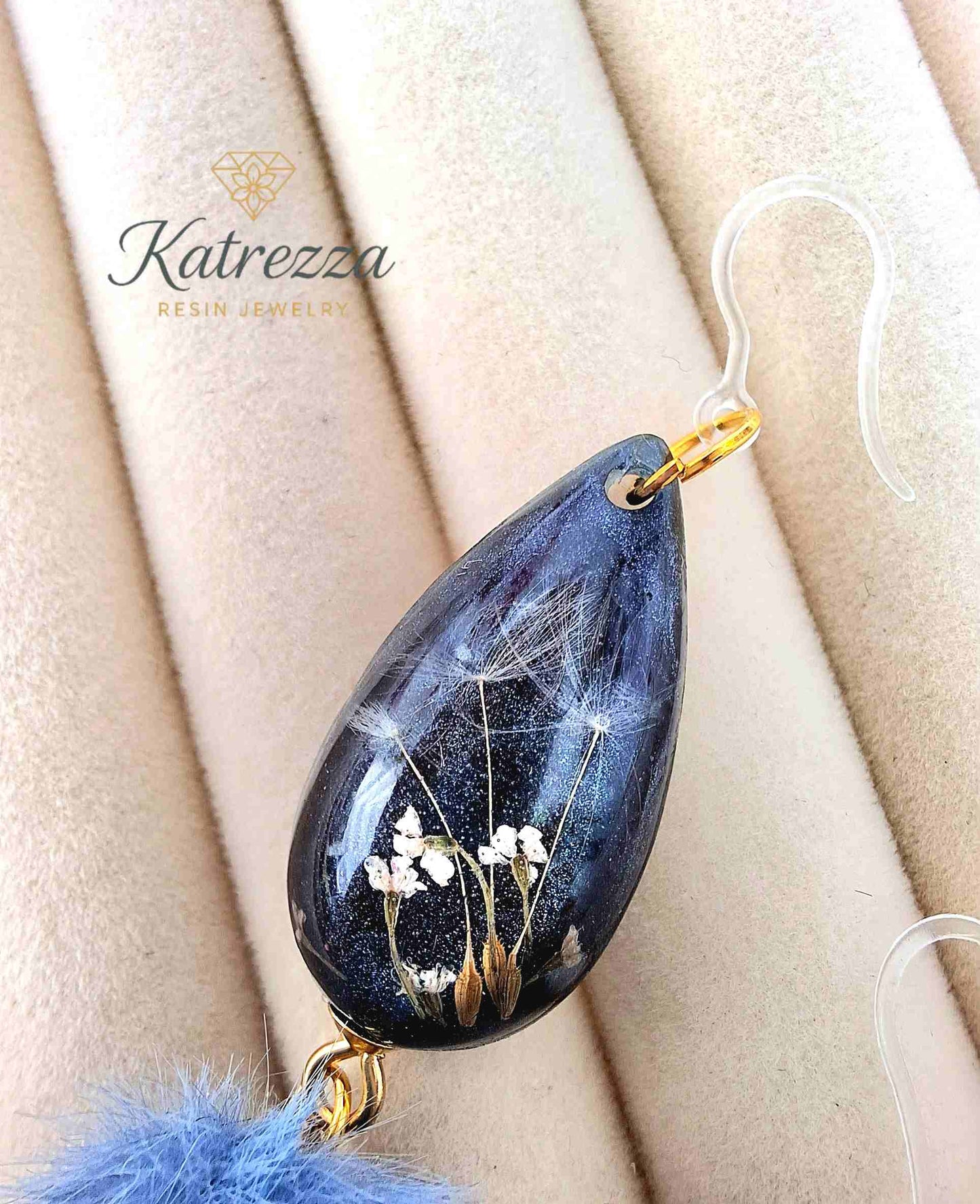 "Detailed close-up of handmade resin earring with preserved flowers and dandelion seeds inside dark glitter resin – Katrezza Jewelry"