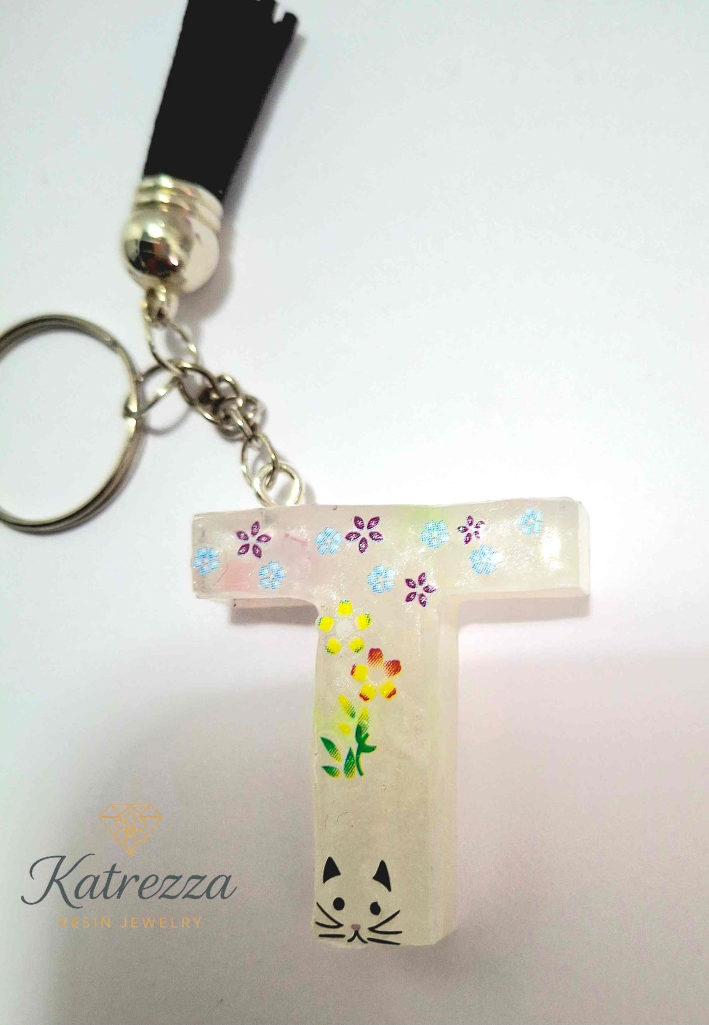 Resin letter T keychain with flower and cat stickers, handmade by Katrezza.