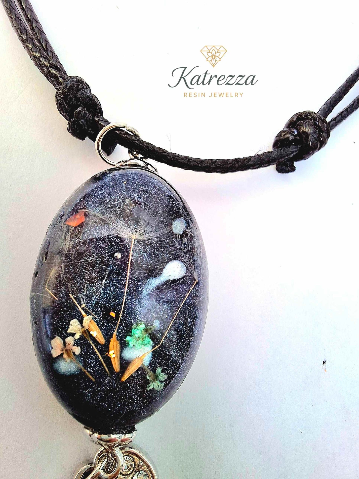 “Handmade resin pendant with tiny Queen Anne’s Lace flowers and dandelion seeds preserved inside black resin – Katrezza artisan jewelry