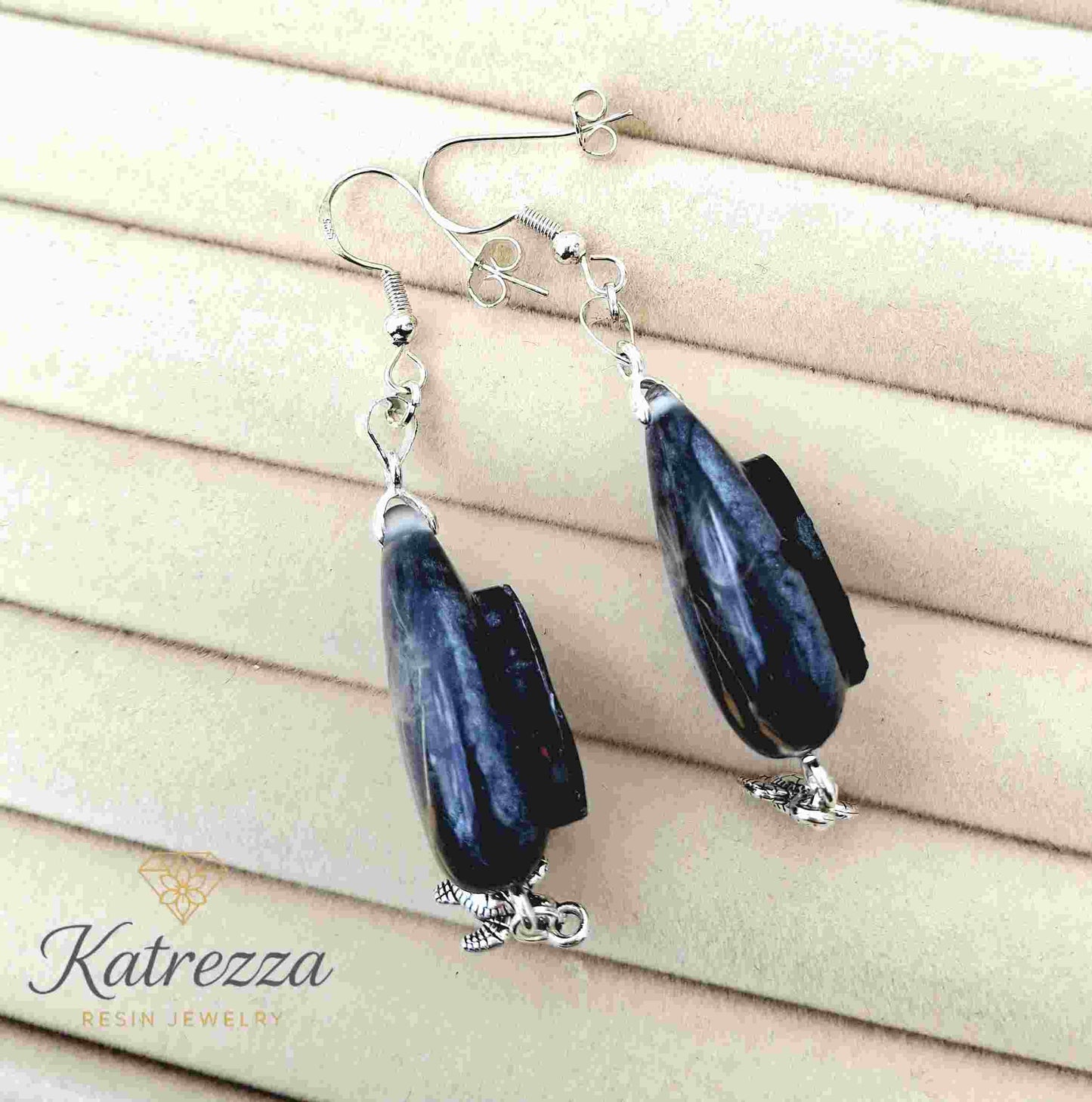 Back view of resin drop earrings with glittery blue resin and turtle charm.