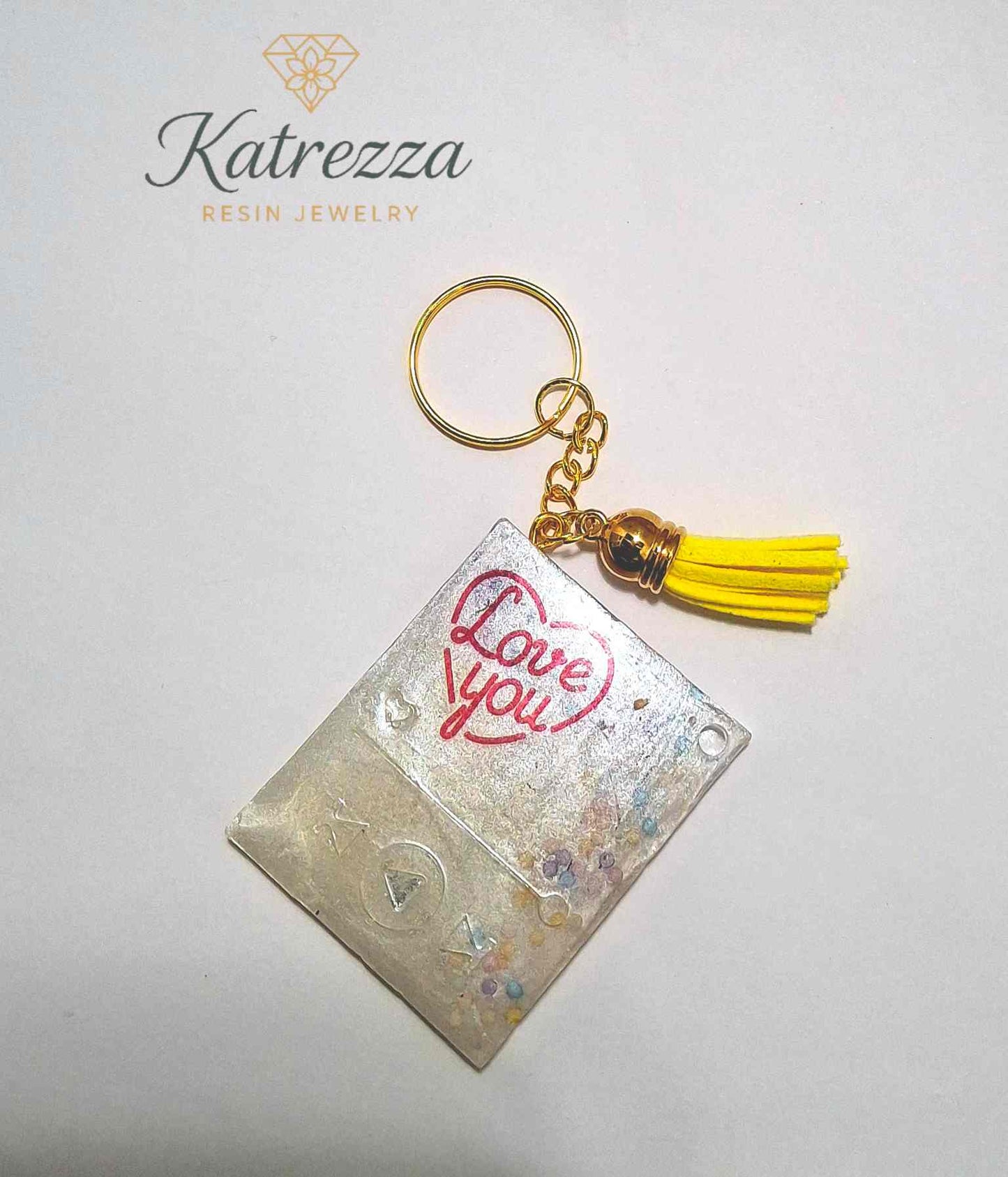 Resin rectangular keychain with “Love You” text, yellow tassel and gold keyring.