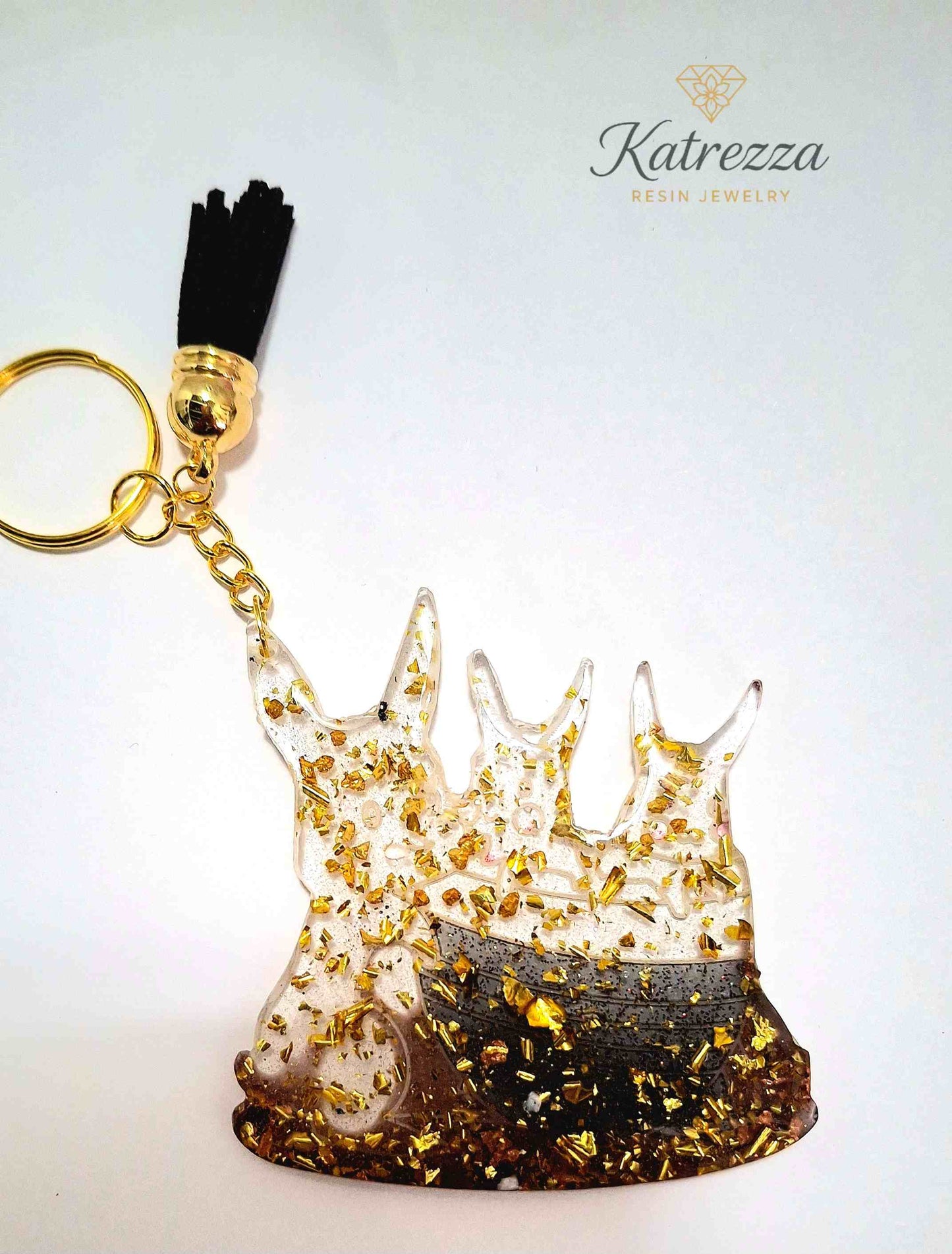Close-up of Pokémon family resin keychain showing golden flakes and three character silhouettes.