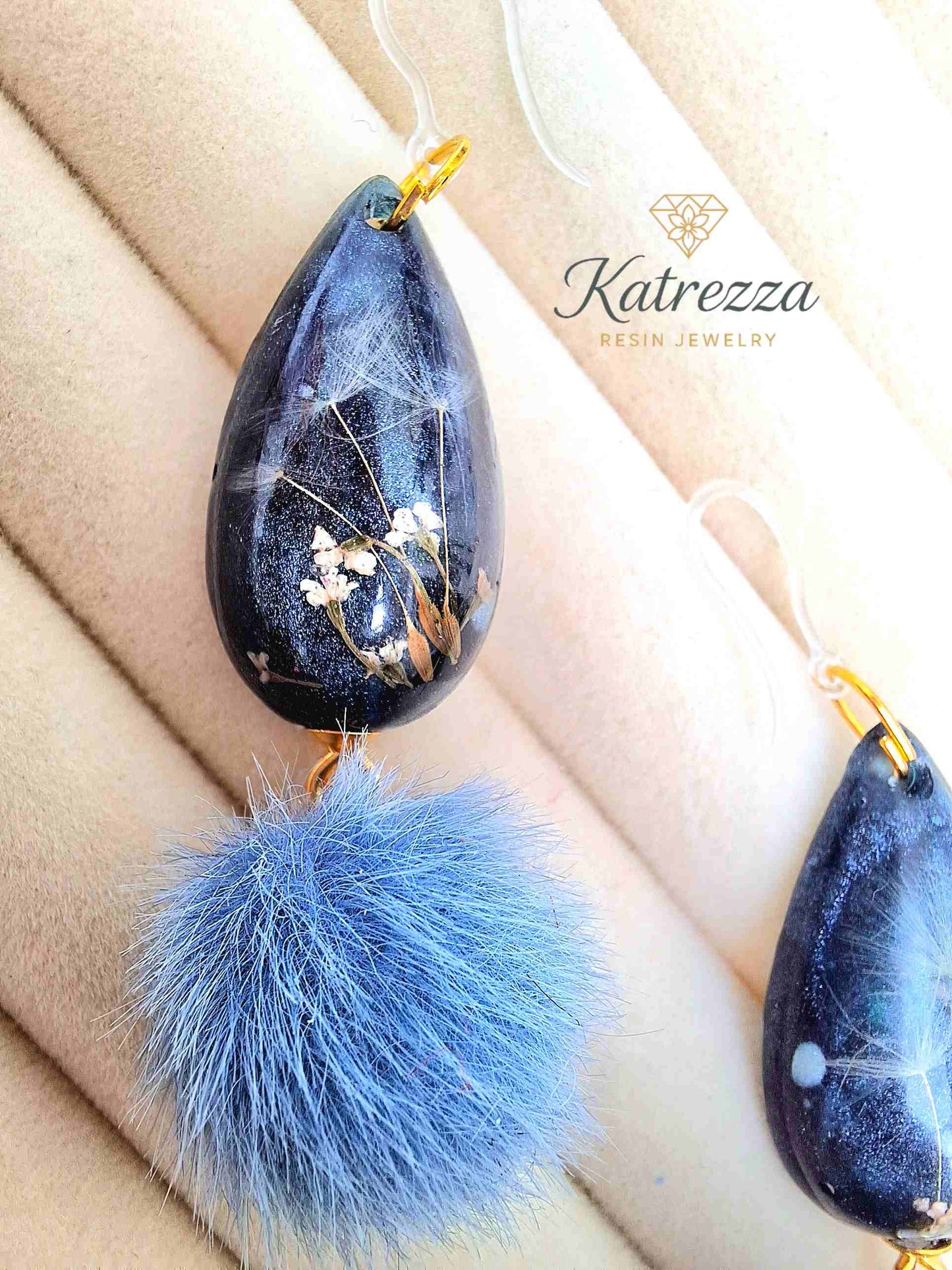"Dark glittery resin teardrop earrings with real dried flowers and dandelion seeds, finished with blue pom-poms – Katrezza Resin Jewelry"