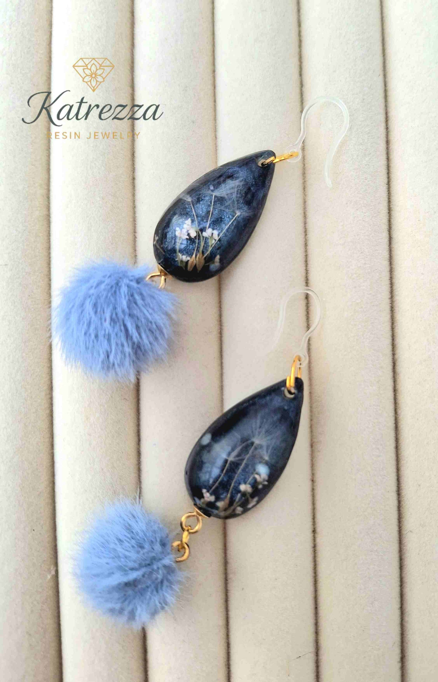 "Close-up of resin teardrop earring showing glittery grey-black base with delicate real dried flowers and dandelion seeds – Katrezza Resin Jewelry"