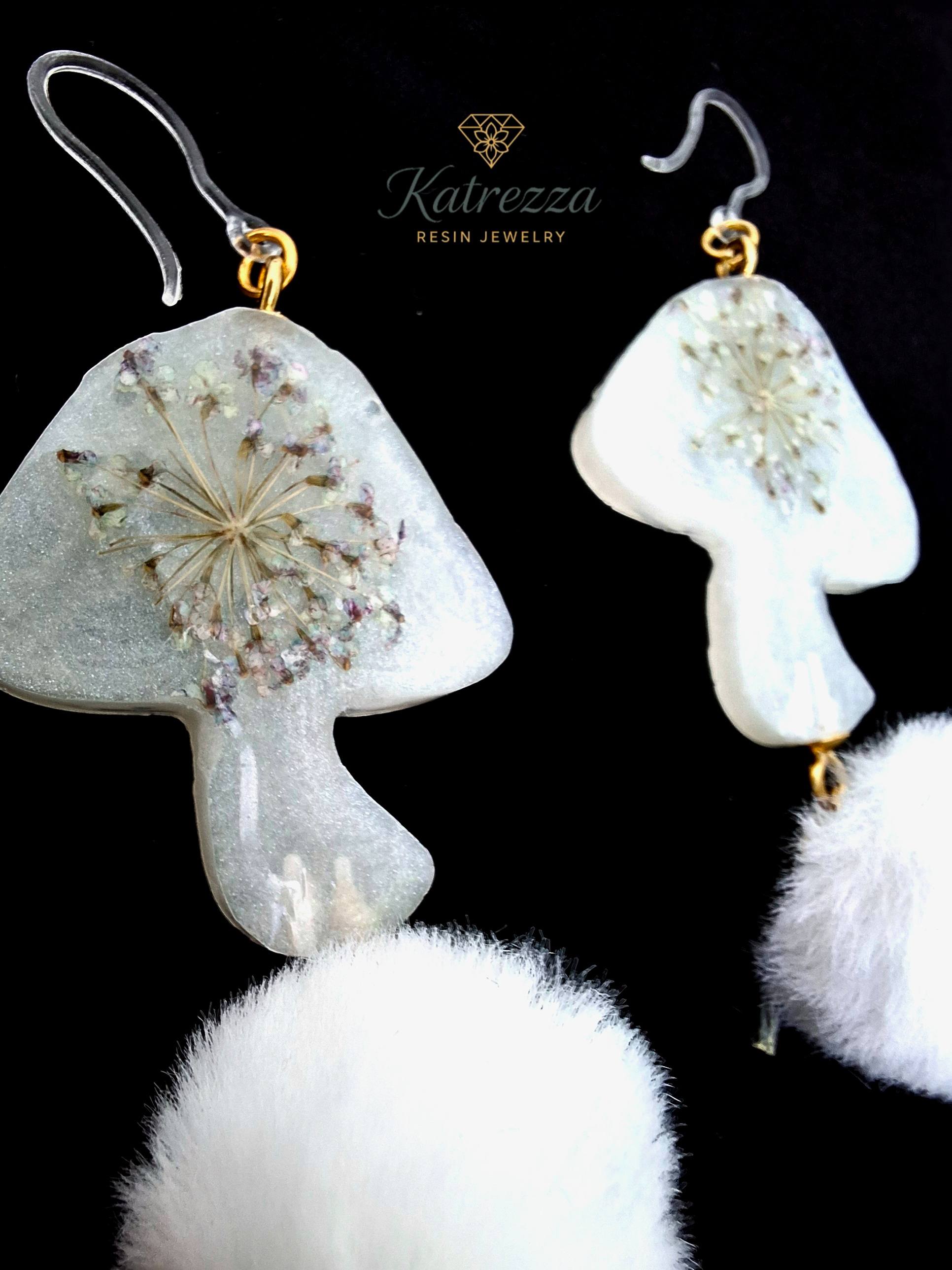 “Reverse side of mushroom resin earrings showing real Queen Anne’s lace flowers preserved inside resin, with white pom-poms and hypoallergenic hooks.”