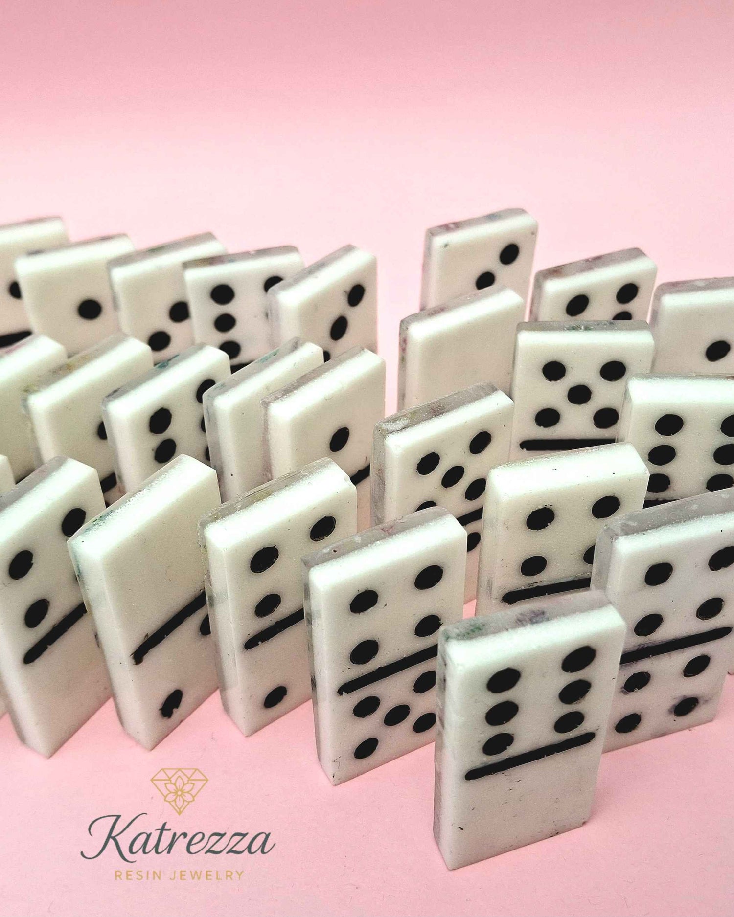 Handmade resin domino set with black pips on white background
