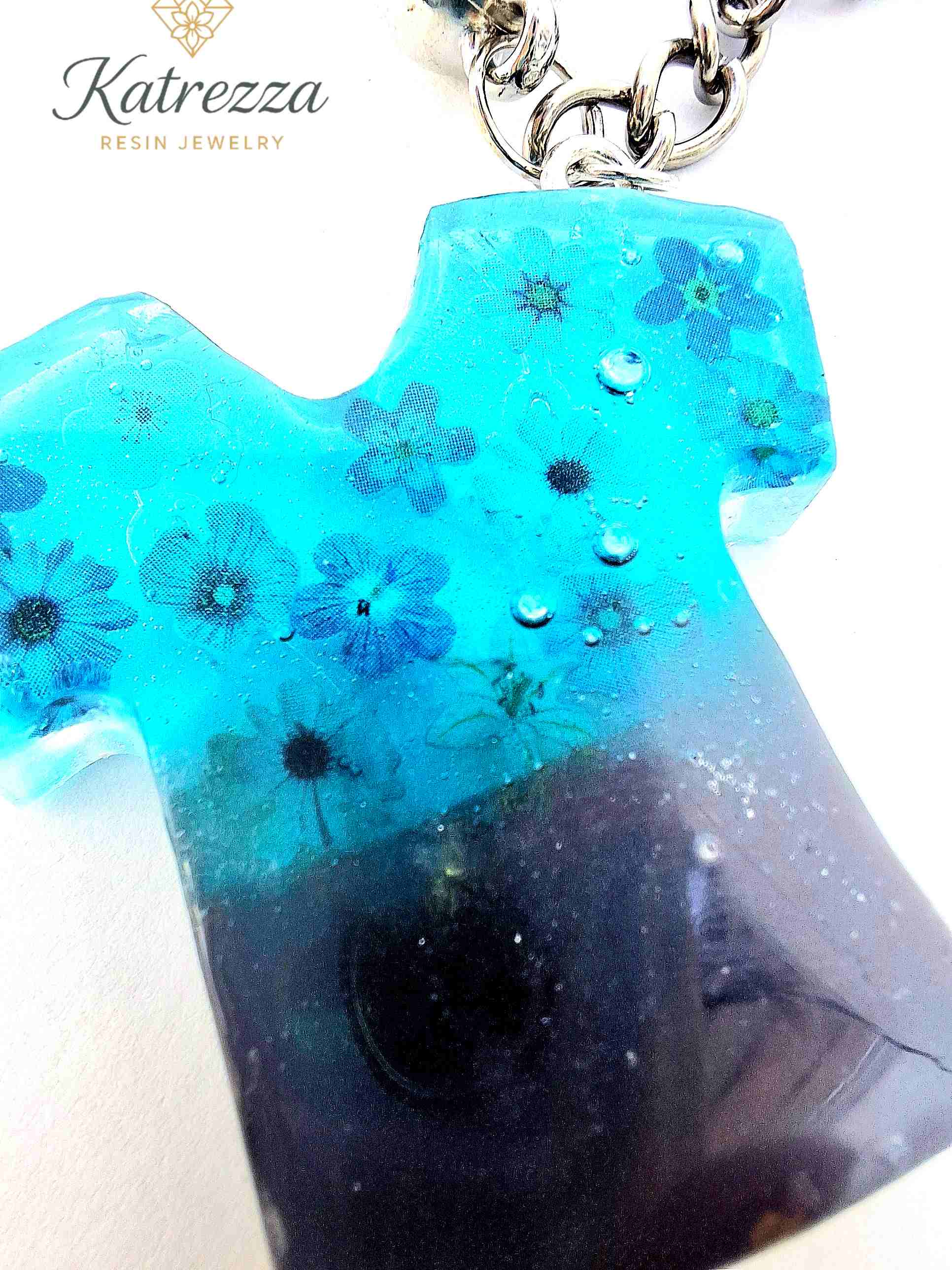 T-shirt shaped resin keyring with glossy finish and flower sticker design.
