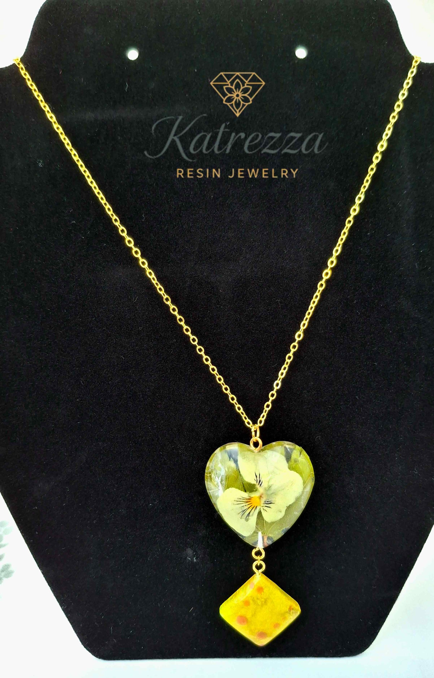 Heart-shaped resin necklace with real pansy flower and yellow resin charm on gold chain, 44 cm chain, 7 cm pendant drop – Katrezza jewelry.
