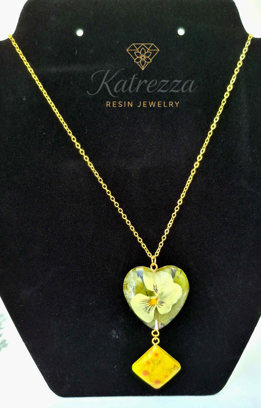 Heart-shaped resin necklace with real pansy flower and yellow resin charm on gold chain, 44 cm chain, 7 cm pendant drop – Katrezza jewelry.
