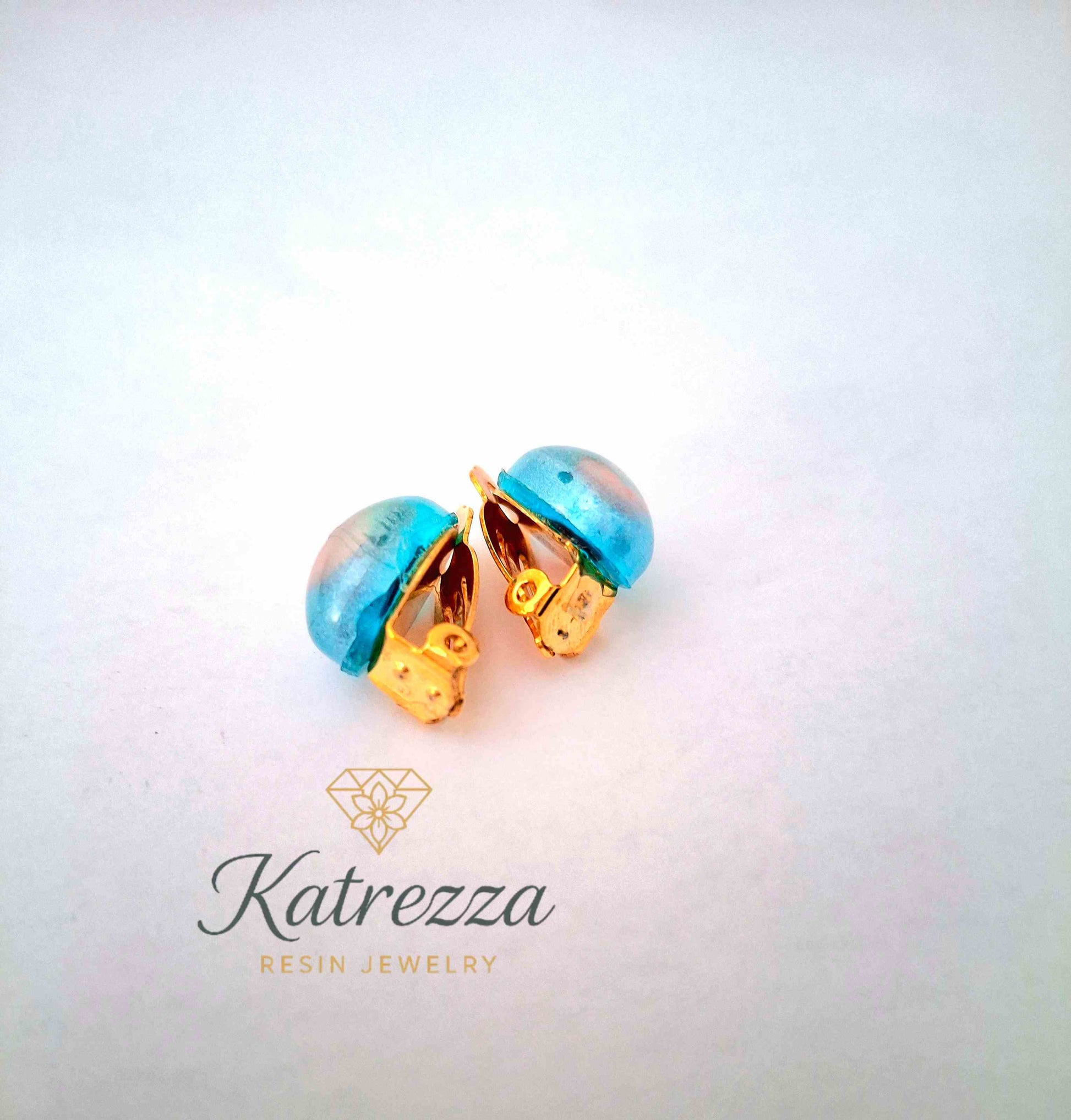 “Resin clip-on earrings for girls – blue and pink design with gold clips, handmade by Katrezza.”
