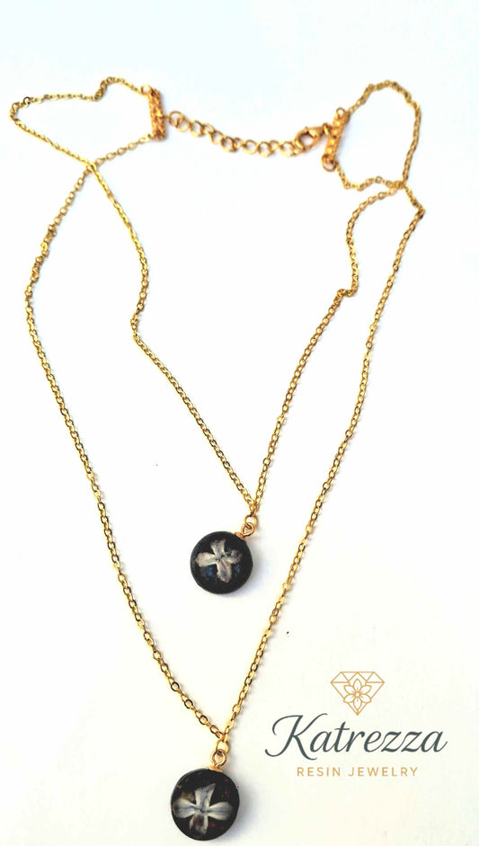 Double pendant resin necklace with real lilac flowers preserved in resin, glitter accents, on a gold double chain – handmade Katrezza jewelry.