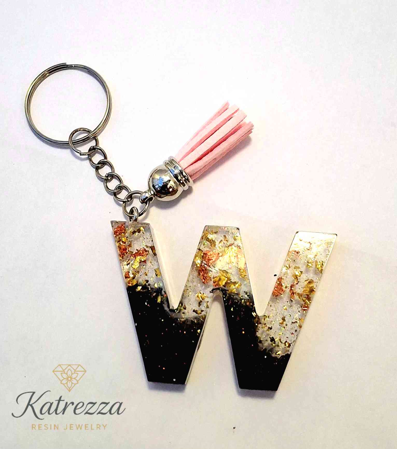 Handmade resin W keychain with black ombre and pink tassel.