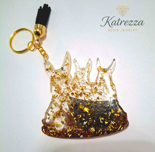 Handmade resin keychain with three Pokémon silhouettes, golden flakes, and black tassel – Katrezza Resin Jewelry.