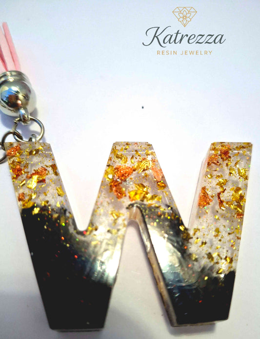 Close-up of resin W keychain with gold and copper foil flakes.