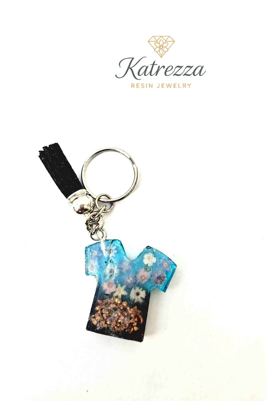 Blue resin T-shirt keychain with flower stickers and tassel charm.
