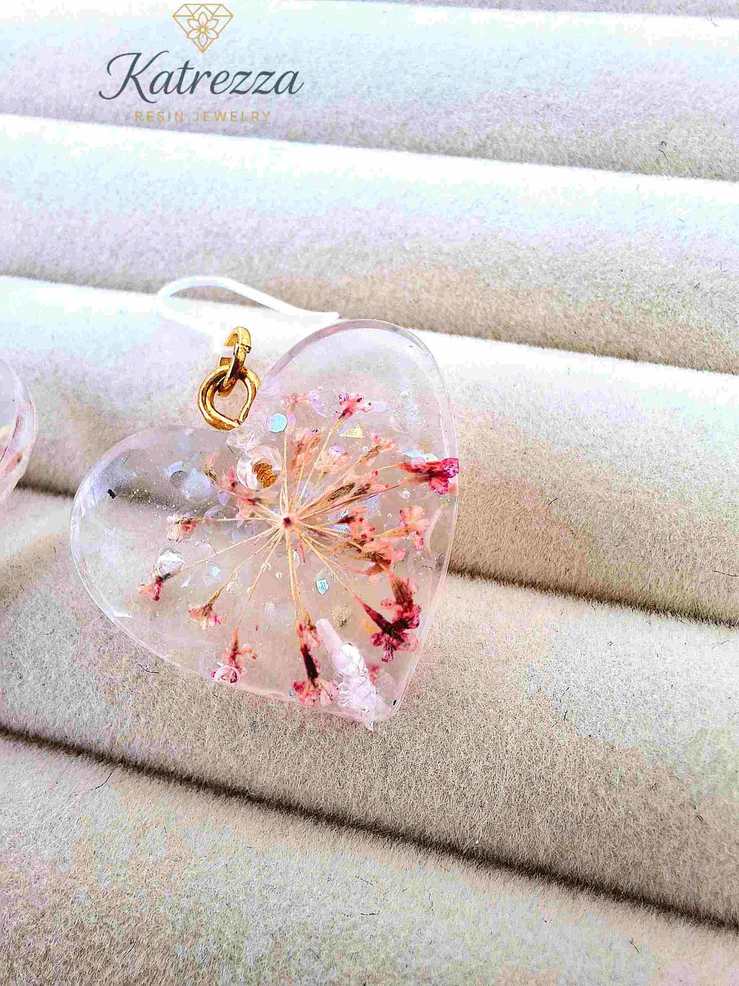 Close-up of pink floral resin earrings with silicone hooks