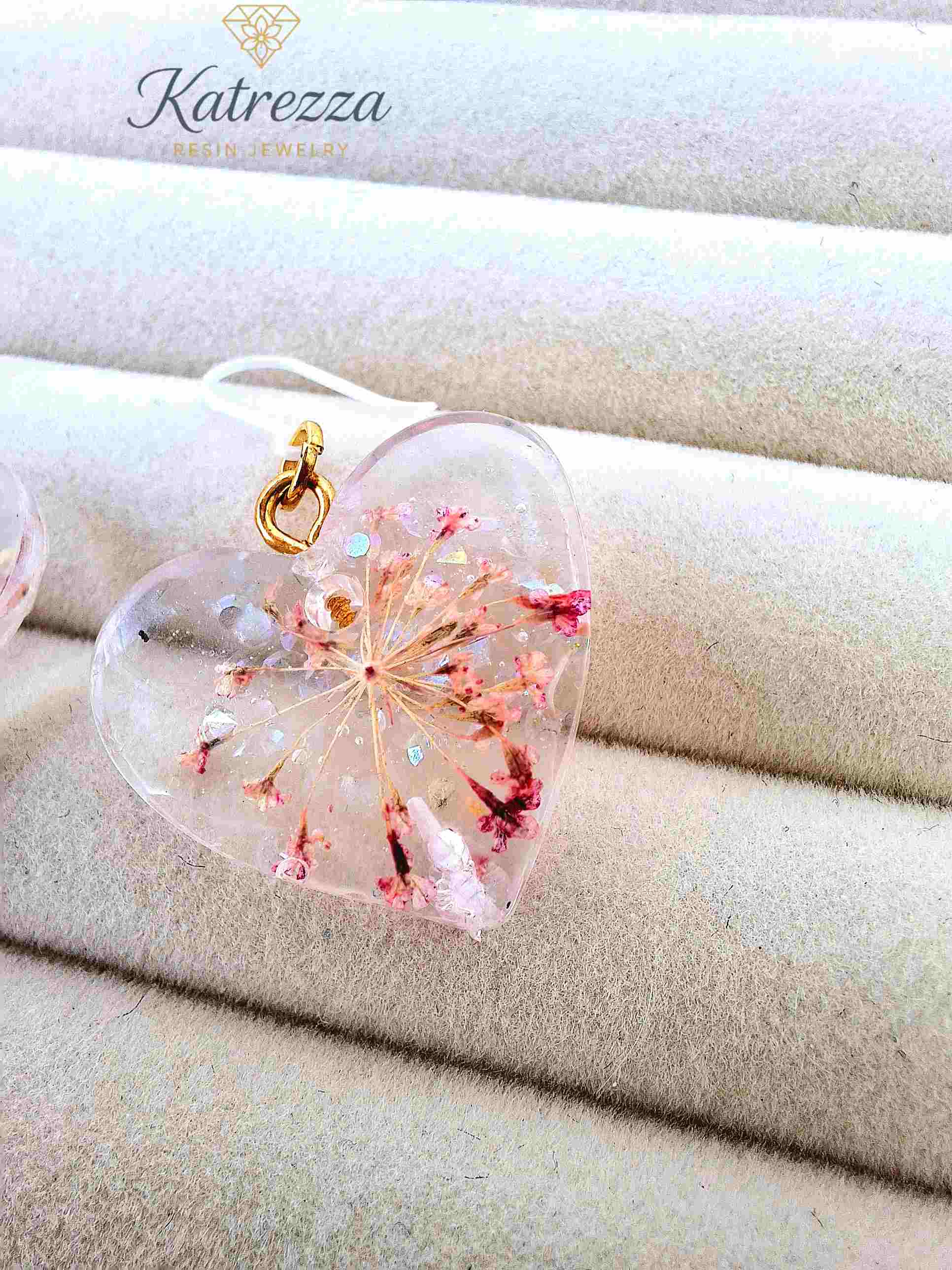 Close-up of pink floral resin earrings with silicone hooks