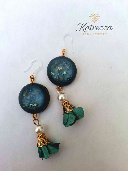 “Close-up of handmade 8 cm resin earring with real pressed flowers, pearl bead, green tassel, and hypoallergenic hook – Katrezza jewelry.”
