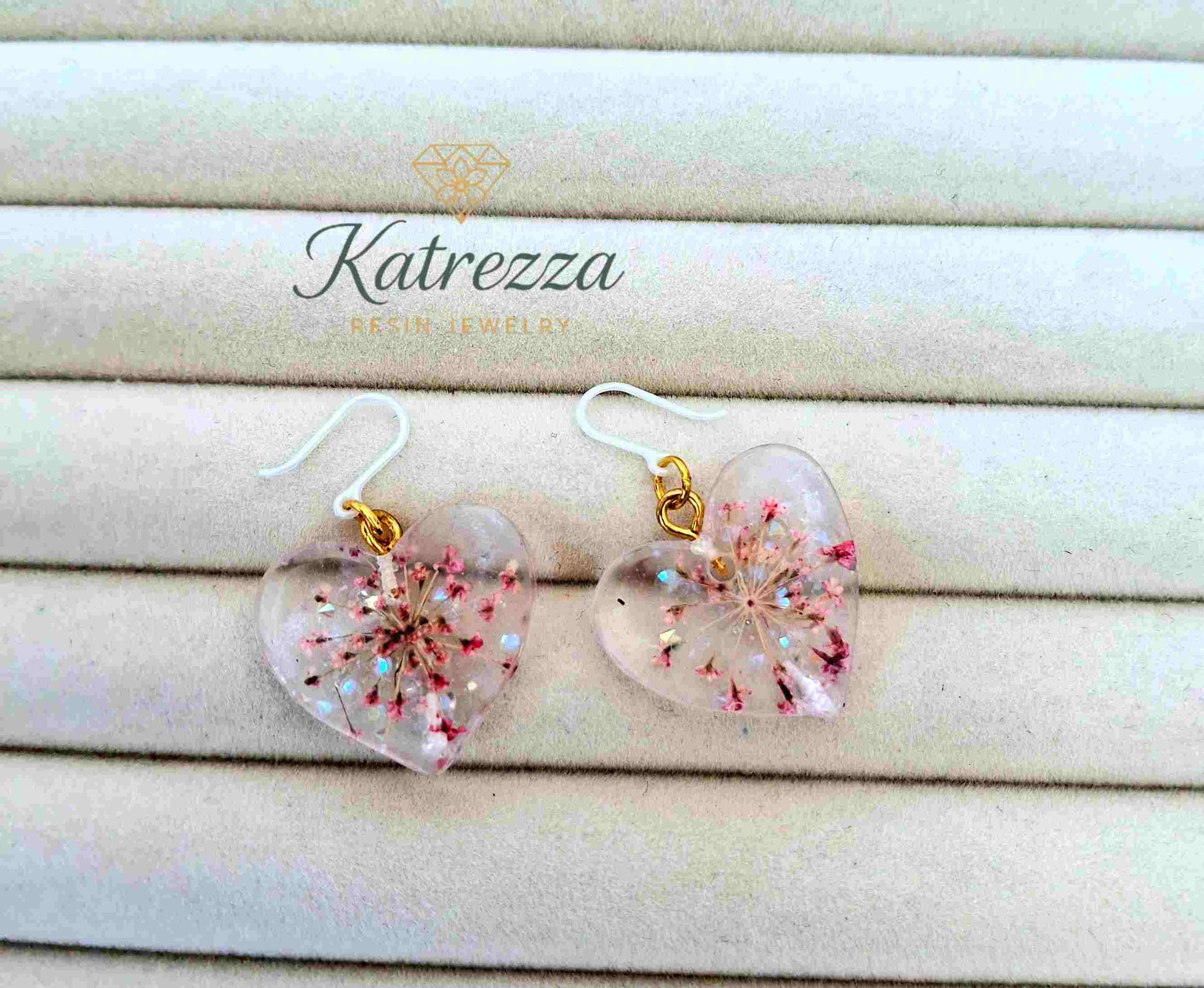 Handmade resin heart earrings with preserved pink blossoms
