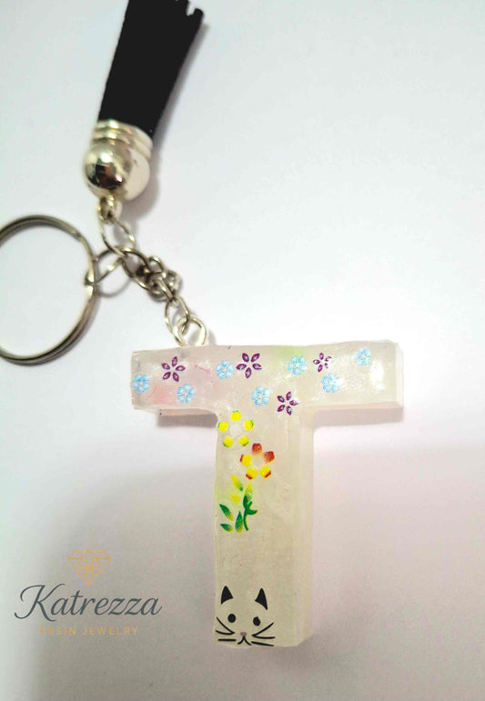 Resin letter T keychain with flower and cat stickers, handmade by Katrezza.