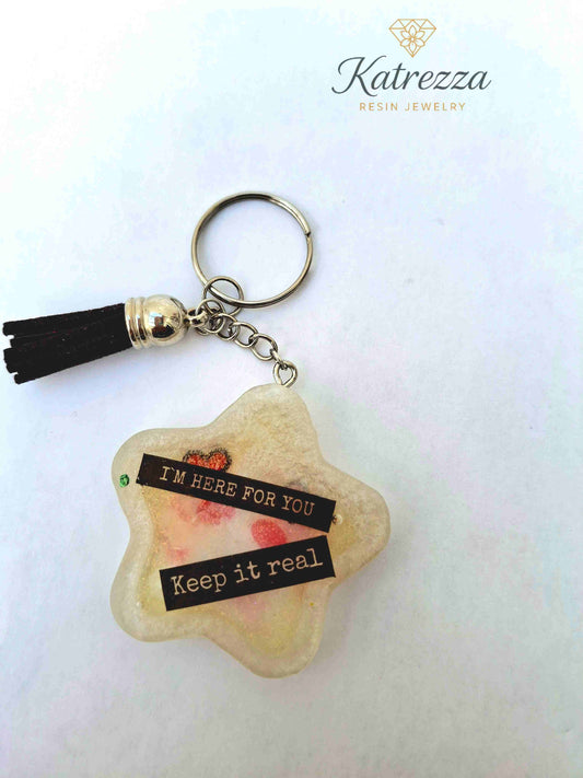 “Star-shaped resin keychain with heart eyes and tassel charm.”
